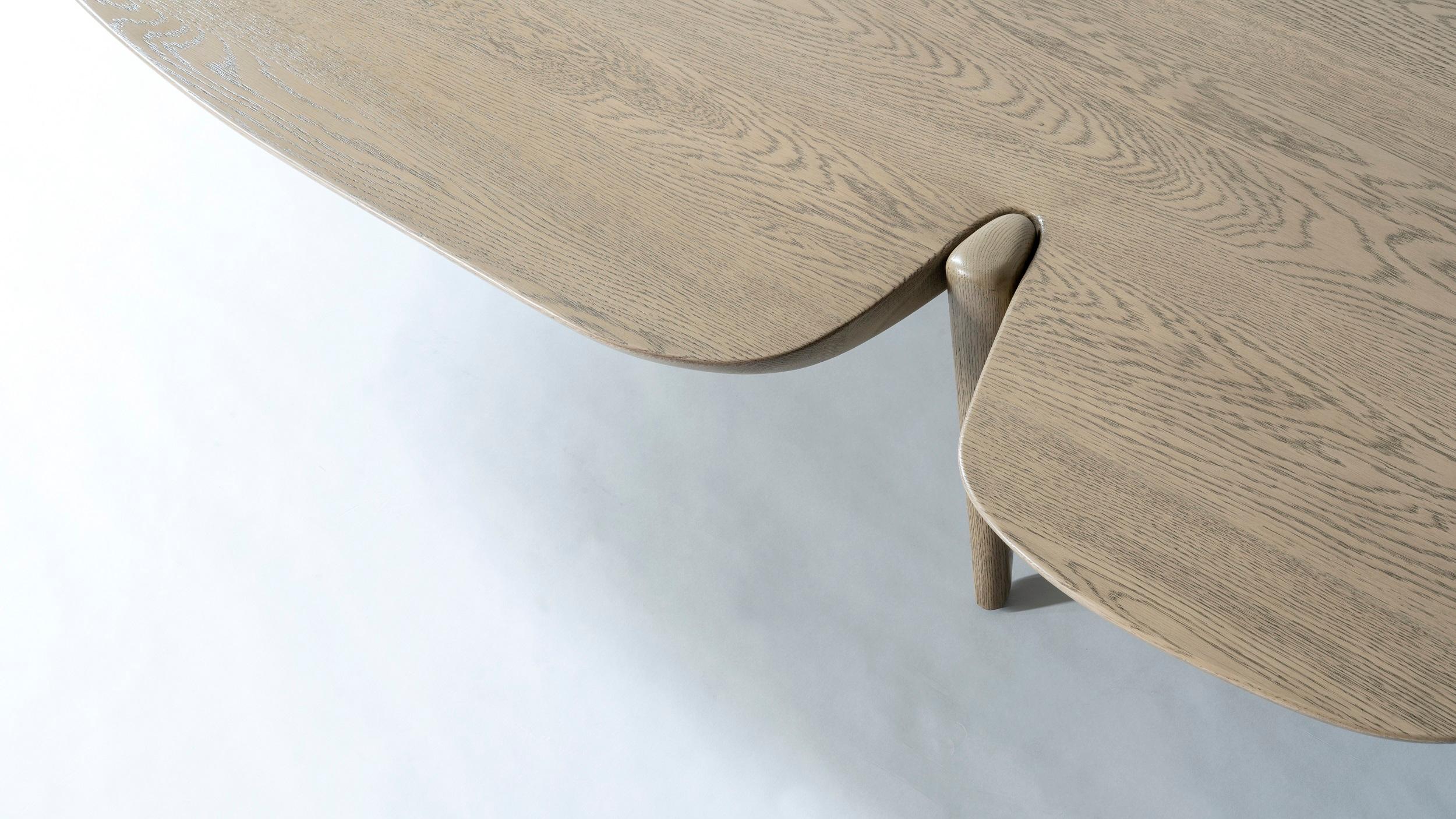 Le squisite superfici solide assumono una qualità fluida nel Contour Center Table. Costruito interamente in legno massiccio, il piano sembra risalire, come un liquido, intorno a gambe elegantemente affusolate. Il risultato è un'esplorazione dinamica