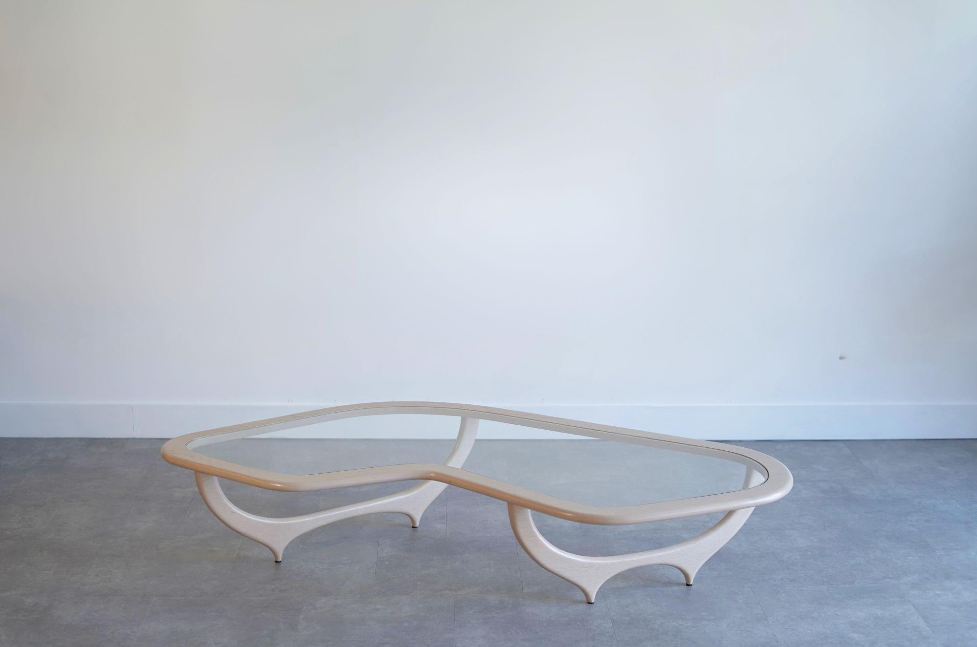 Wir präsentieren unseren Contour Couchtisch - ein modernes Meisterwerk, inspiriert von Ico Parisi. Mit Präzision aus massivem Nussbaum oder Eiche handgefertigt, bieten seine organischen Konturen und sein Glaseinsatz eine harmonische Mischung aus