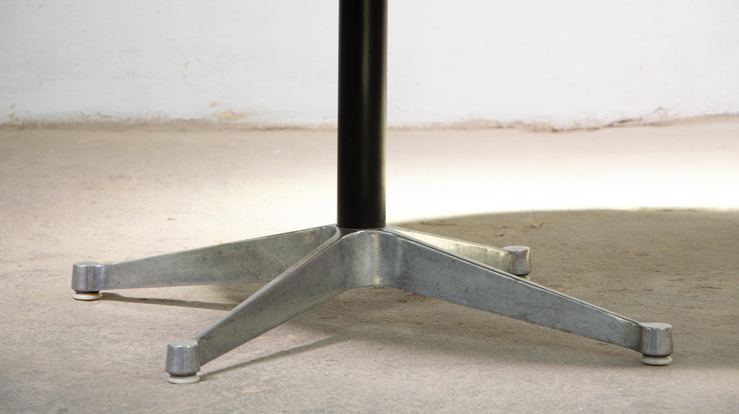 Vintage round conference table by the Eames Aluminium Group for Herman Miller (1964)

This one is from the 70s. 

The structure is in aluminum and black lacquered steel. It provides superb stability with its central 4-leg base, similar to that of