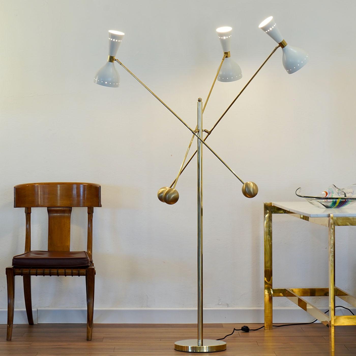 The Contrappeso Terra Brass Floor Lamp combines modern design with functional elegance, featuring a distinctive three-arm configuration that reinterprets the iconic midcentury Triennale lamp. Adorned with twin Giano shades, this lamp showcases a