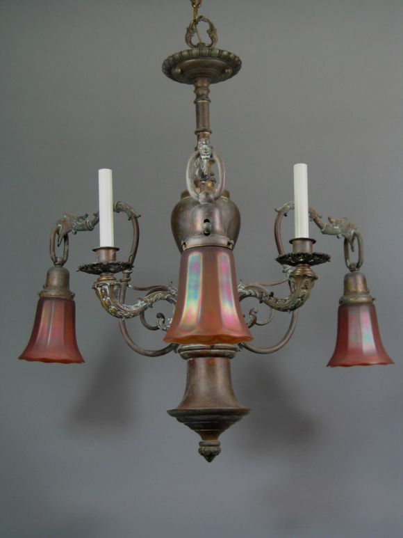 Bronze gas fixture converted to electricity with three candle lights and three art glass shades.

  