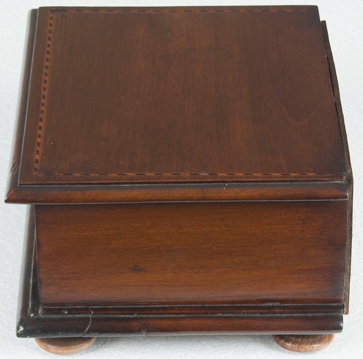 This stunning antique jewelry box is the perfect small gift for someone or for yourself! The box is mahogany wood with satinwood and ebony inlays. A single drawer is fitted with a brass ring pull and lined with green felt. Also it is joined with