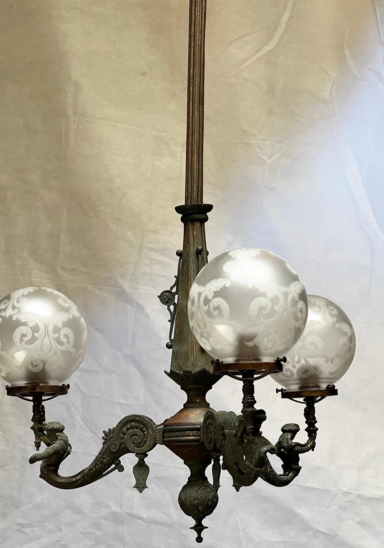 Once a turn of the last century, gas light fixture. Now a converted to electric, modernized for safety, stunning chandelier.
We kept the original finish, as found, which is beautiful aged green on the brass. There is both brass and cast 'pot-metal