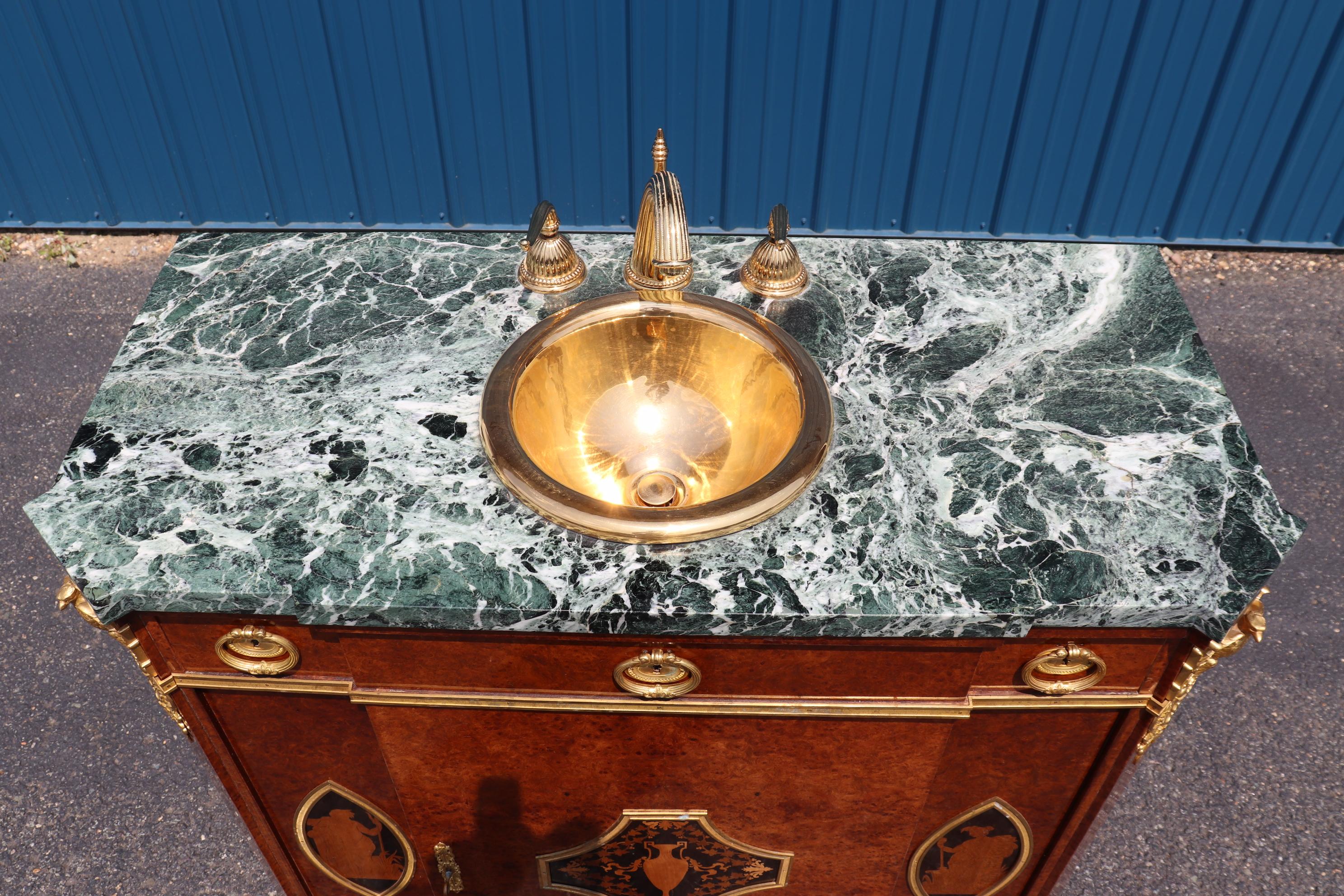 This is a special vanity with sink already installed. The owners evidently didn't understand what they had, and took a museum piece and made a sink out of it. The piece is made of gorgeous burled walnut and features incredible dor'e bronze mount
