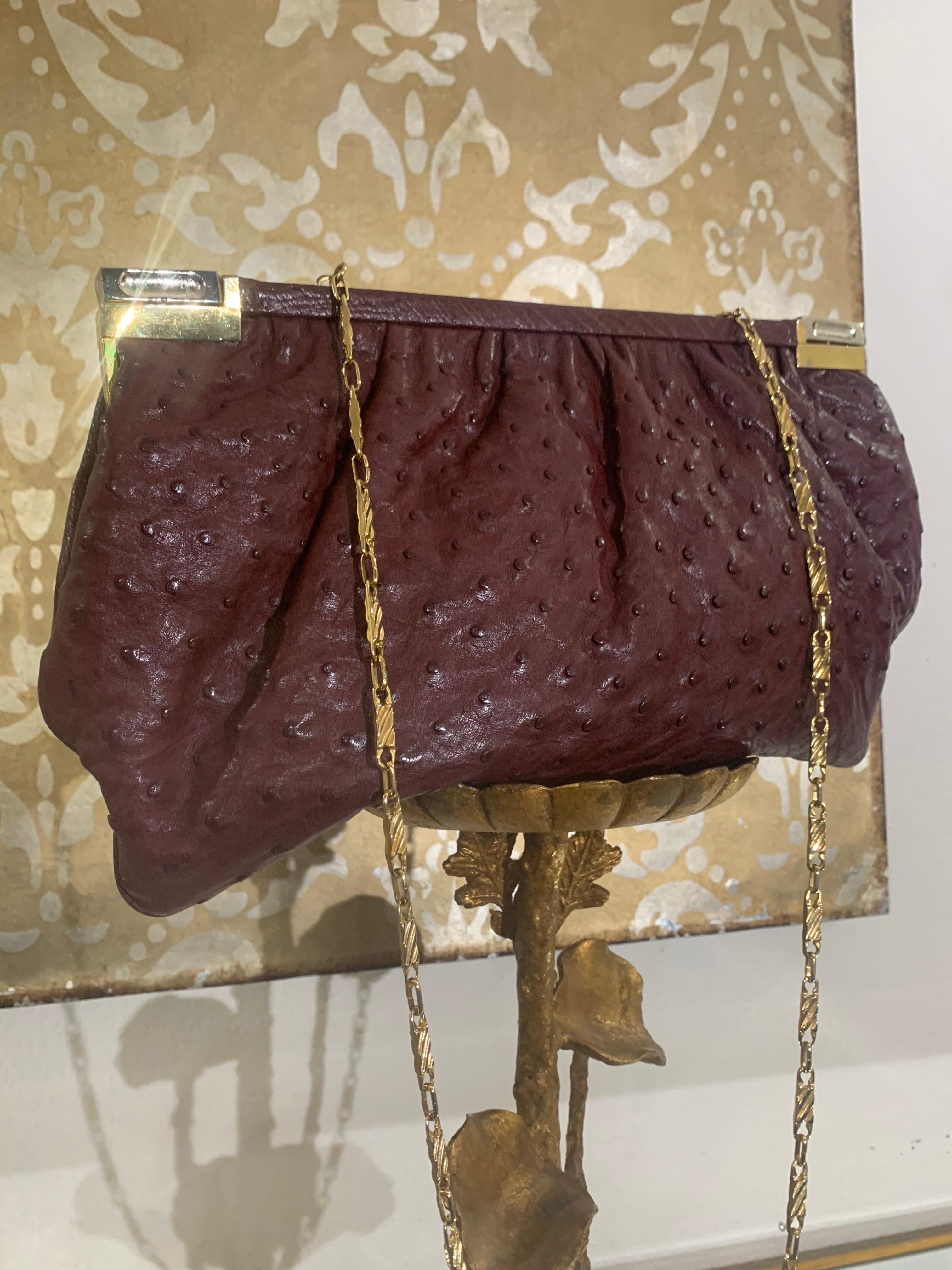 Convertible Fiorenza Chain Handle / Clutch Bag in Burgundy Ostrich Skin:  A super-sleek and functional genuine ostrich skin bag with two-tone hardware in chrome and gold, can be worn with shoulder-length chain handle or tucked inside as a clutch! 