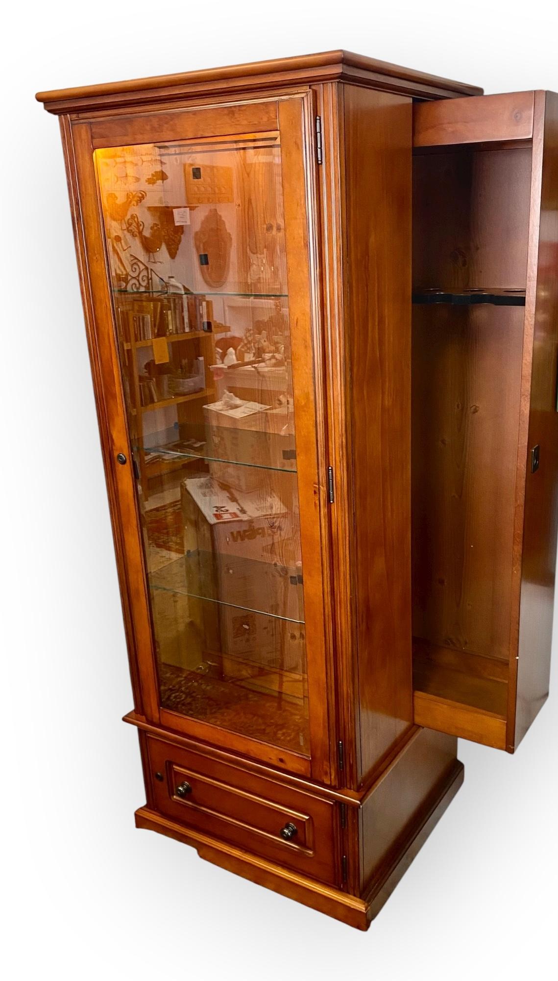 Si tratta di una vetrinetta convertibile in legno di ciliegio, che può funzionare sia come vetrinetta che come armadietto per le armi.
Funzionalità del mobile da salotto: La sezione principale con l'anta in vetro smussato, l'illuminazione e i tre