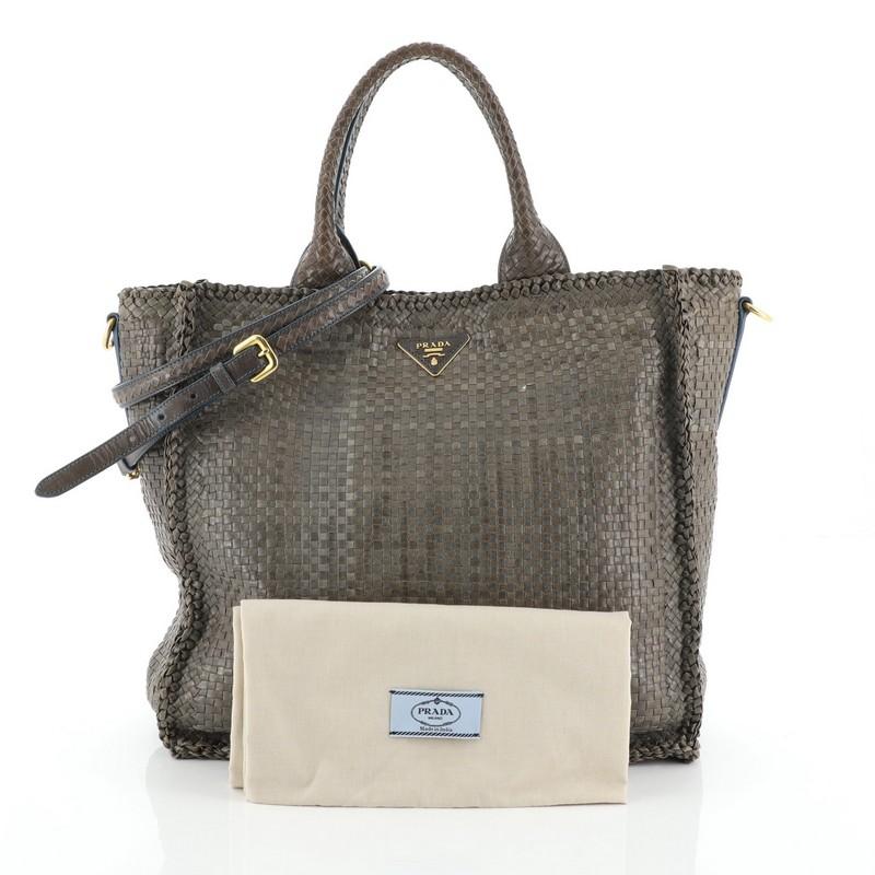 This Prada Convertible Open Tote Madras Woven Leather Large, crafted in gray woven leather, features dual top handles, Prada triangle logo, protective base studs and gold-tone hardware. Its snap button closure opens to a neutral fabric interior with