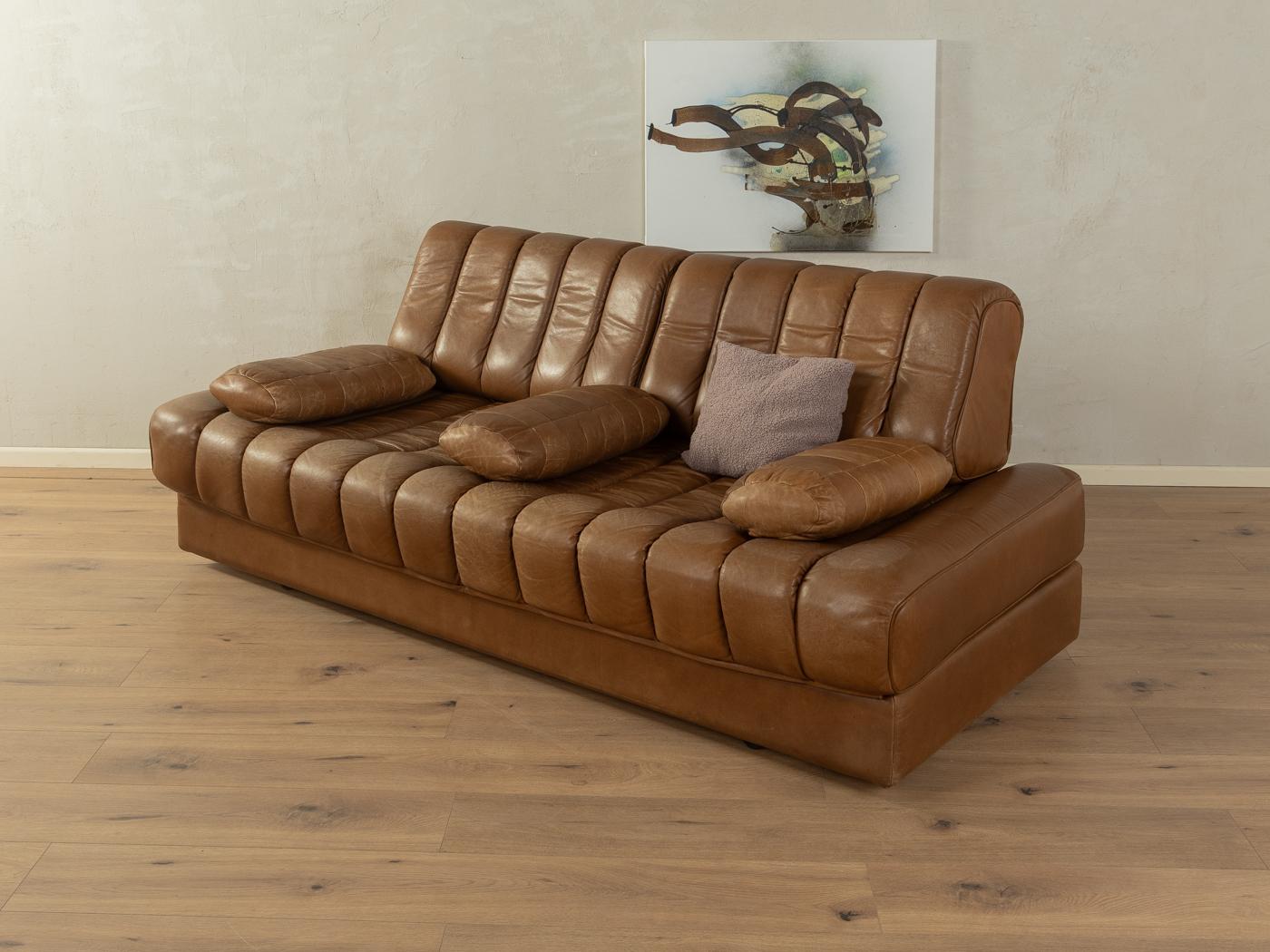 
Article Details
Rare convertible sofa bed from the 1970s. Model DS-85 by de Sede with the striking original cover made of brown buffalo leather with a wonderful patina. The sofa can be turned into a double bed by simply folding down the