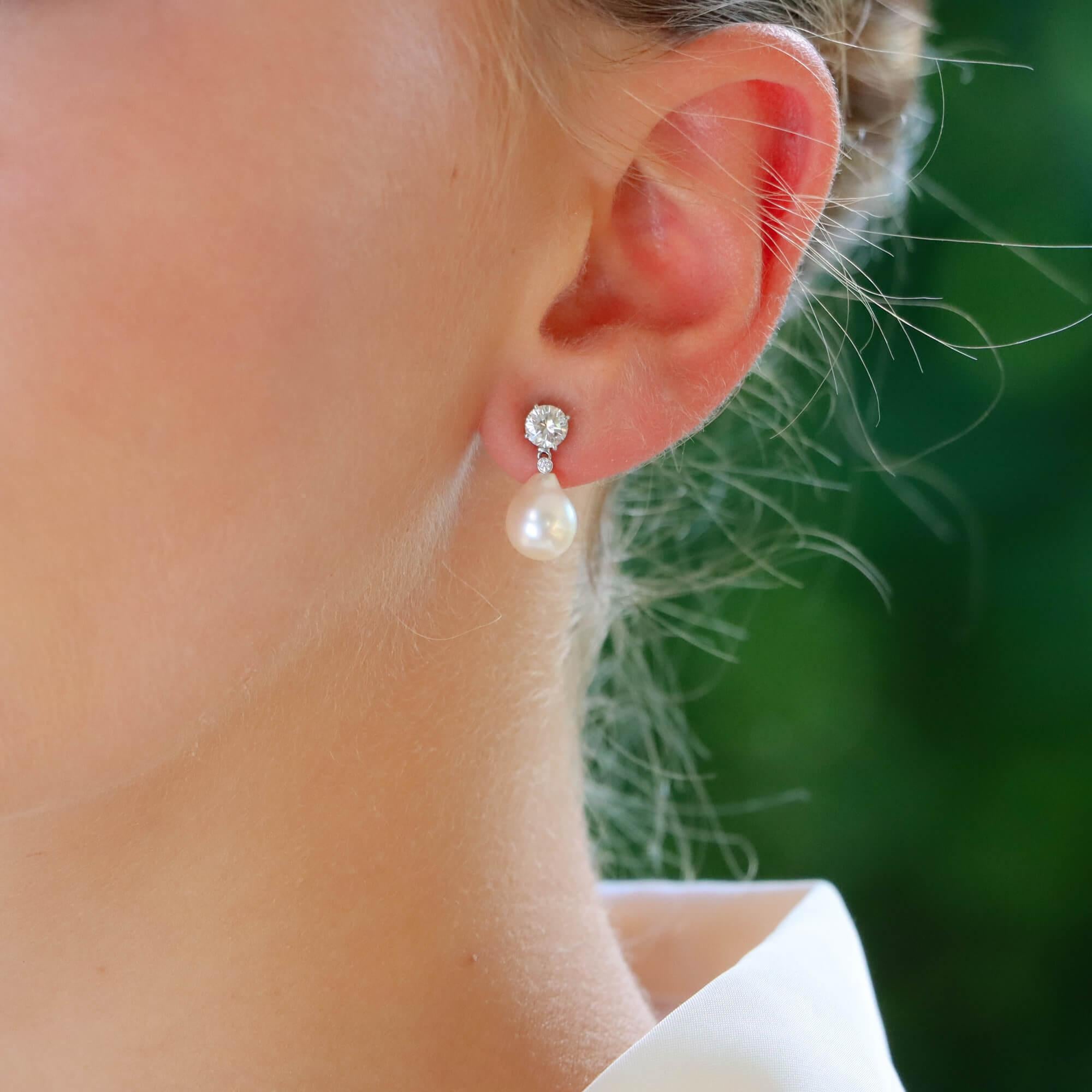  A beautiful pair of convertible pearl and diamond earrings set in 18k white gold.

Each earring is firstly composed of round brilliant cut diamond stud earring. The diamond is four claw set in an open back setting and secured to reverse with a post