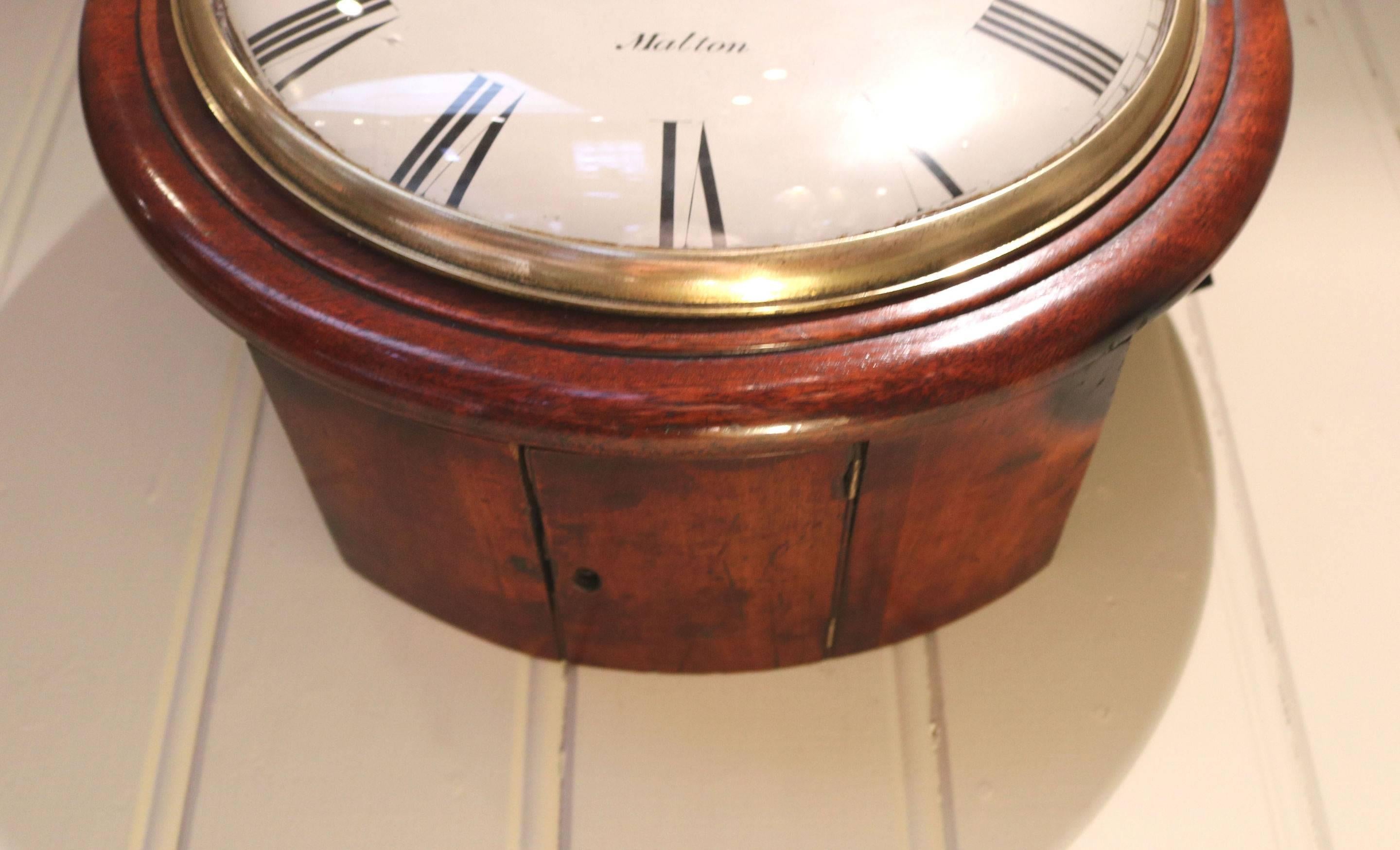 A very original mid-19th century 12 inch convex dial clock. It has a rich medium mahogany outer bezel, a traditional pegged case, a cast bezel with a convex glass. The painted convex enamel dial is signed by the maker, Staniland of Malton. It has an