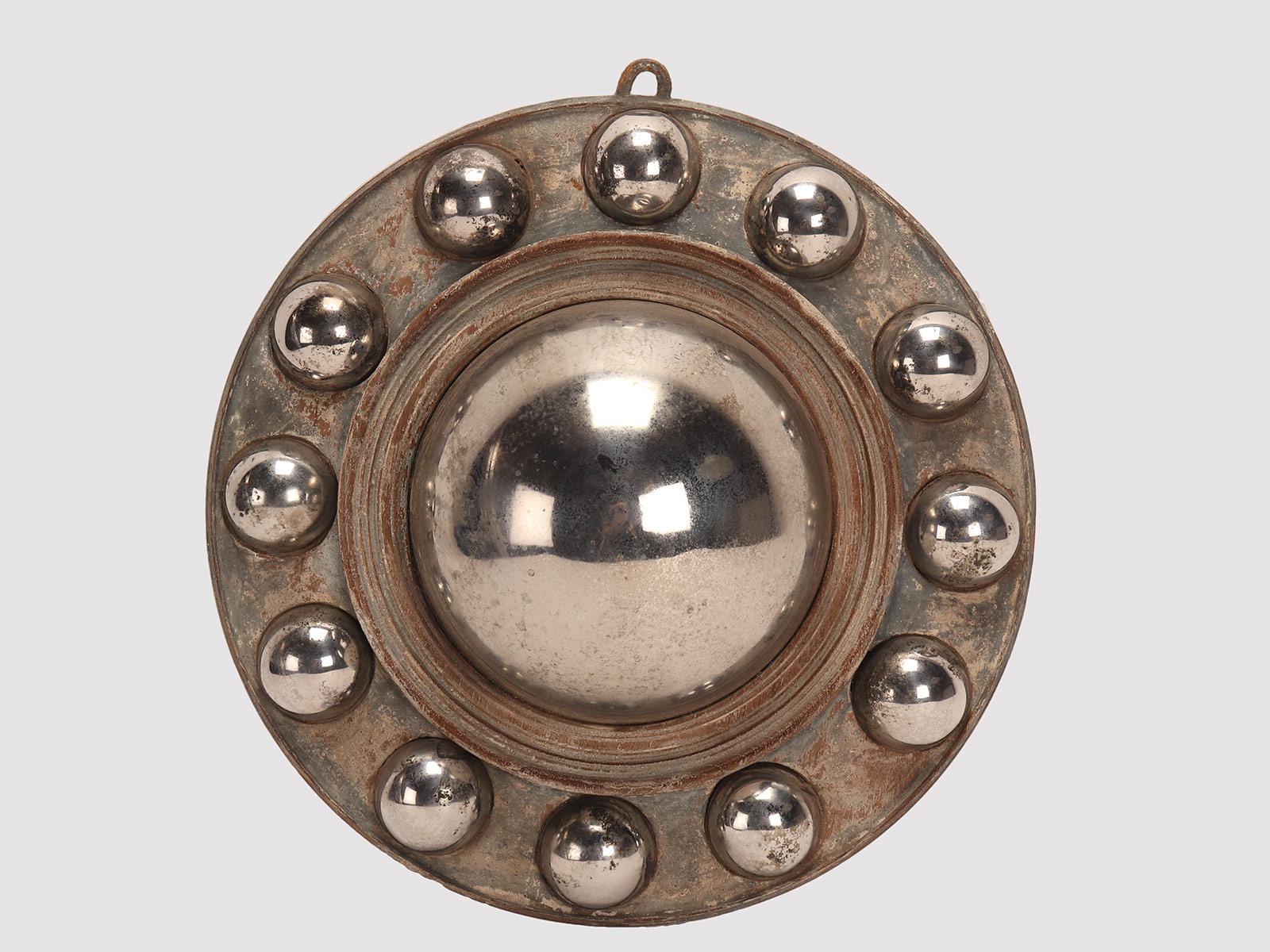 A large central convex metal mirror, with 12 small convex metal mirrors along the edge of the round frame. These convex mirrors were called 