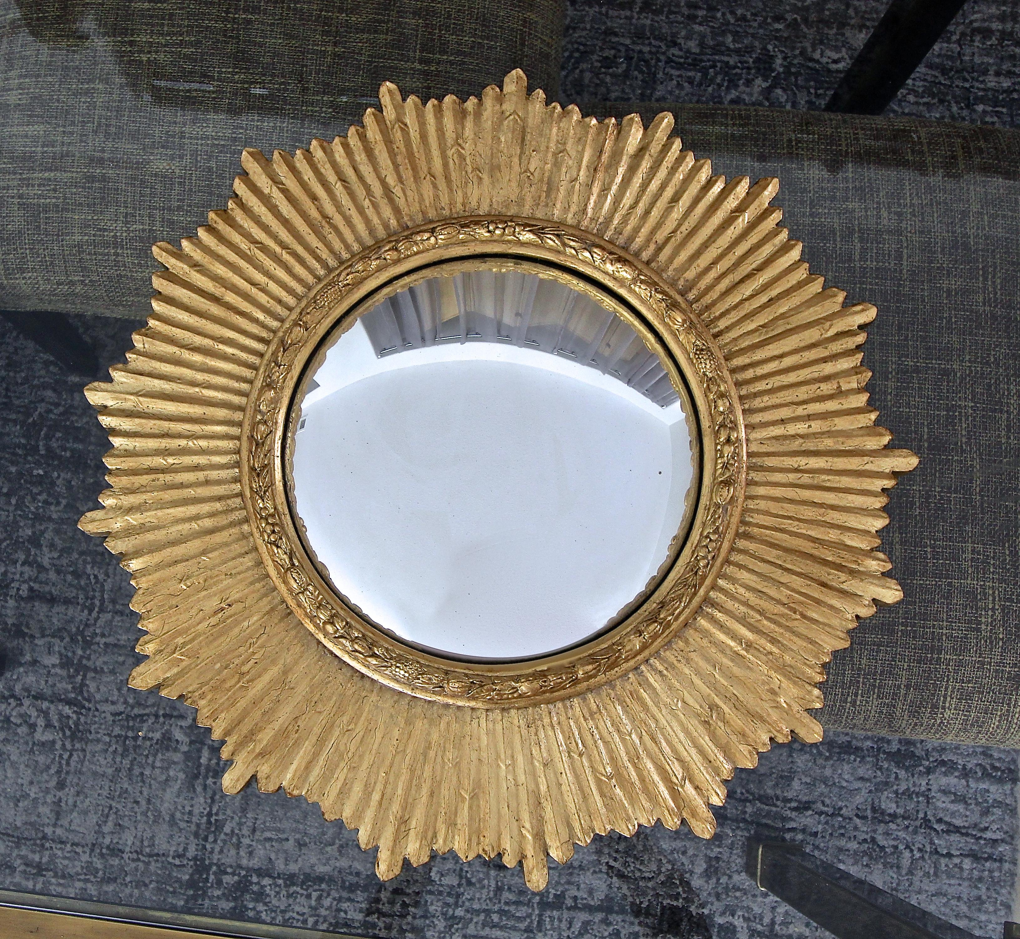 Round giltwood sunburst or starburst wall mirror with convex mirror.