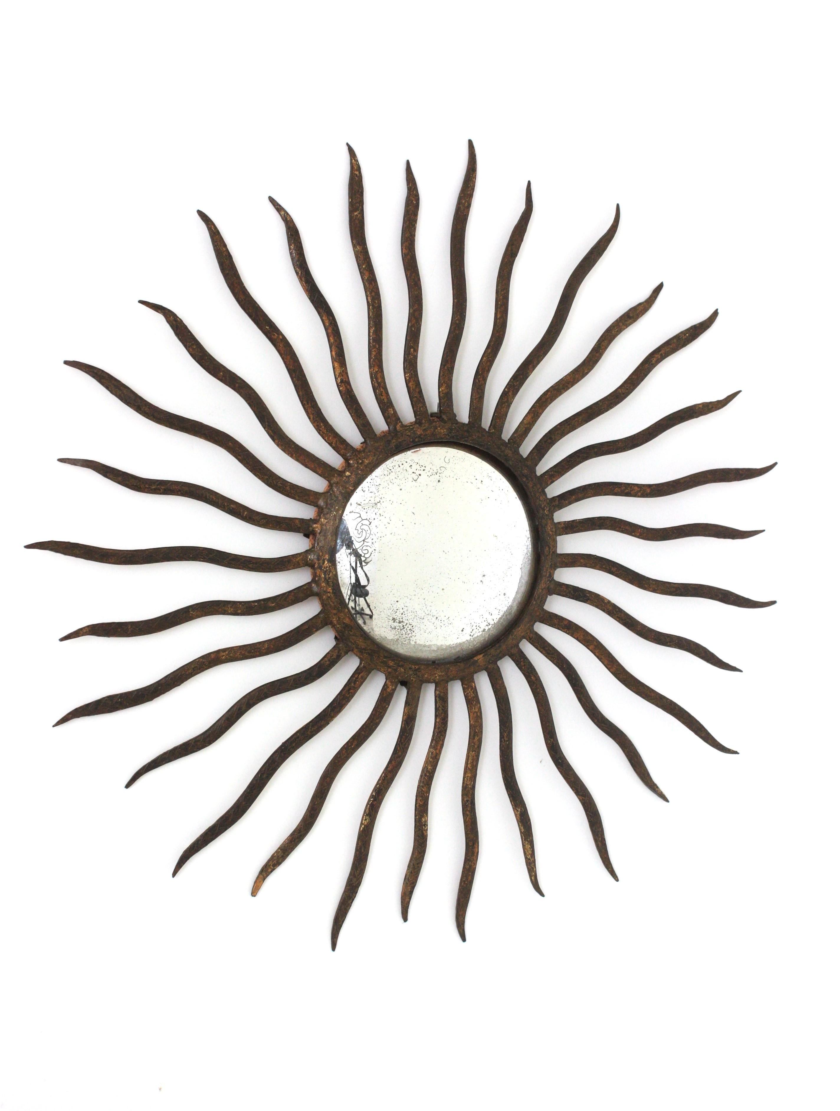 French Convex Sunburst Mirror in the Style of Gilbert Poillerat, Parcel Gilt Iron, 40s For Sale
