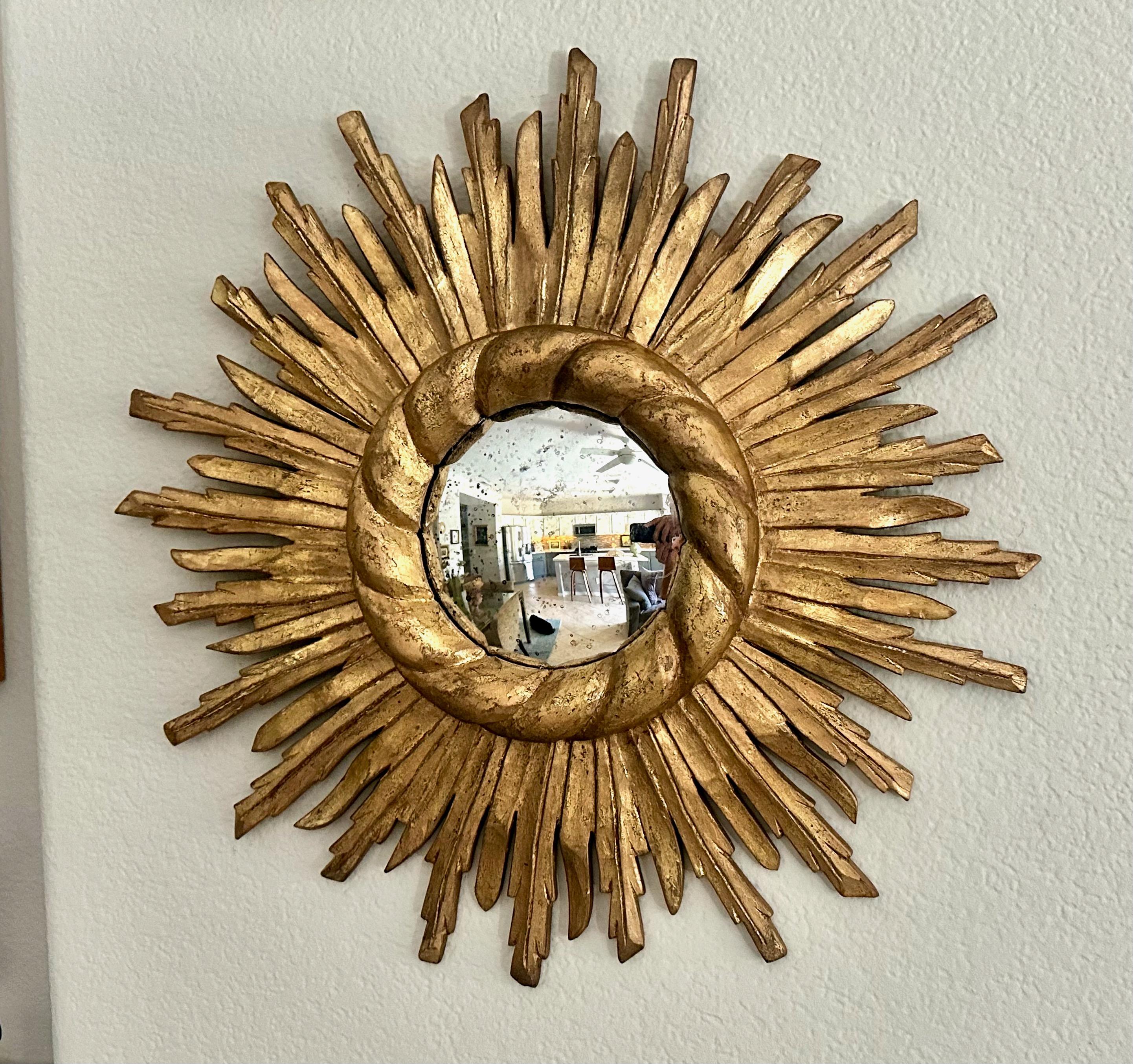 Round gilt wood sunburst or starburst wall mirror with antiqued convex mirror. Overall diameter of mirror 20