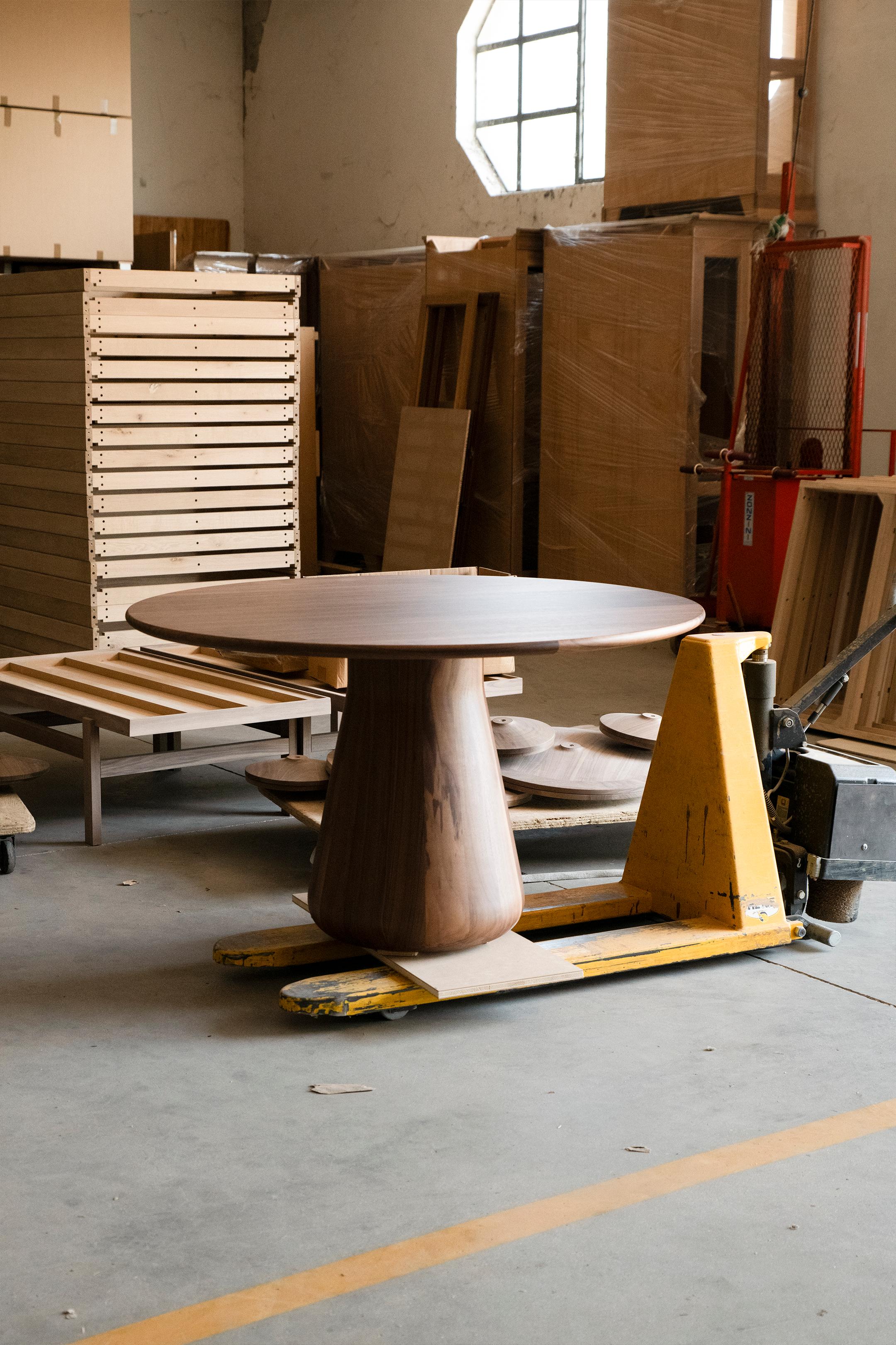 La rencontre d'un design contemporain et d'un savoir-faire italien traditionnel donne naissance à une pièce unique. La table est le résultat de l'union de deux matériaux de première qualité : le noyer massif en finition huilée et le cuir italien