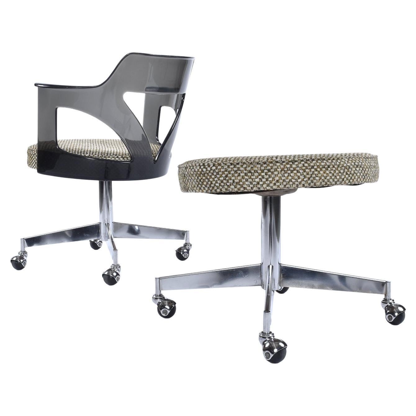 Vintage 1970s Space Age smoked acrylic armchair and a foot stool by Conwed. Our restoration team hand polished this dark gray Lucite armchair to a brilliant sheen. Both the chair and stool have caster wheels. This set is ideal for use in an office