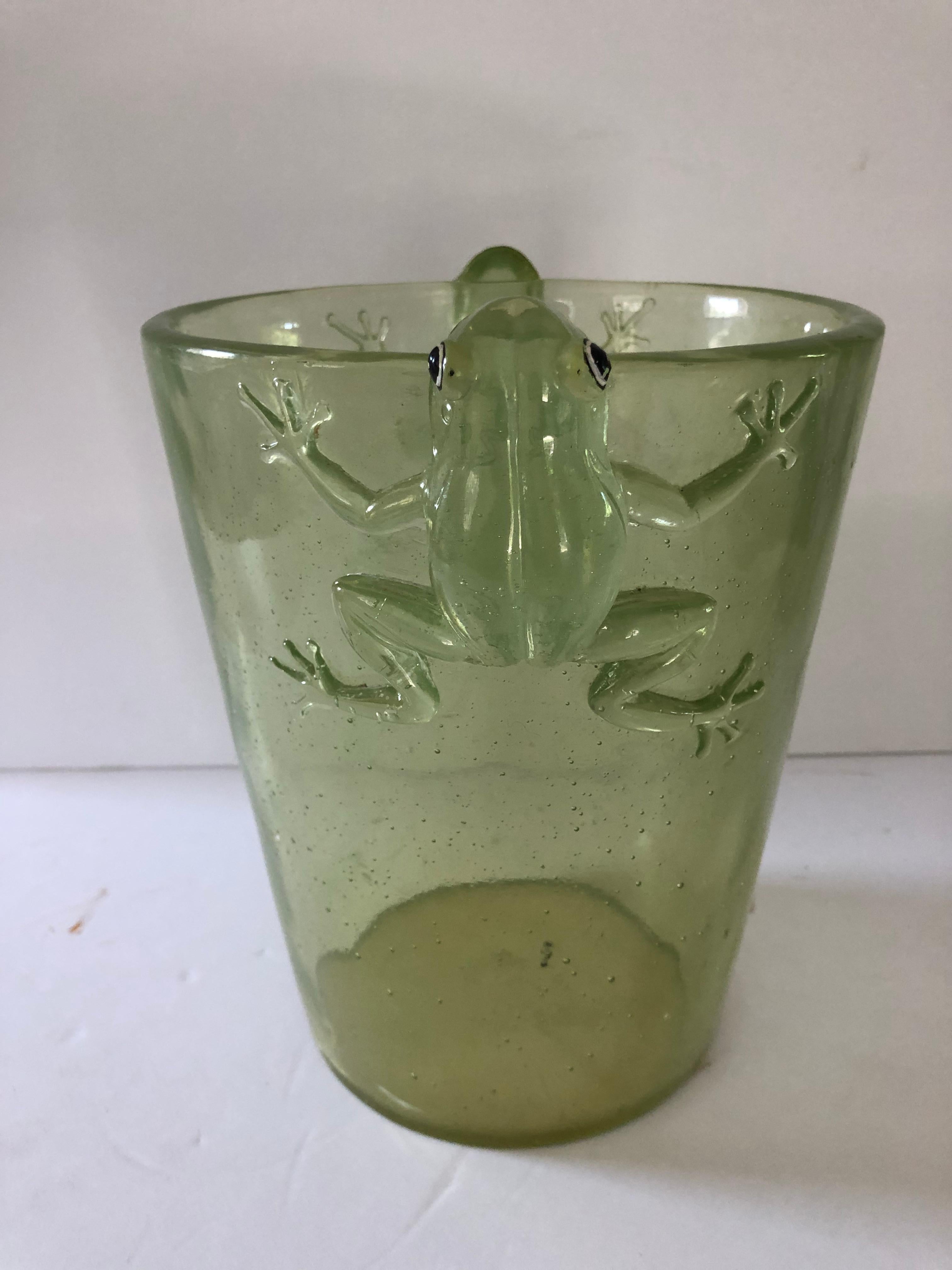 Thick acrylic ice bucket in a green translucent color and decorated with a frog on each side. Frogs have black and white eyes and appear to be grasping onto the bucket.