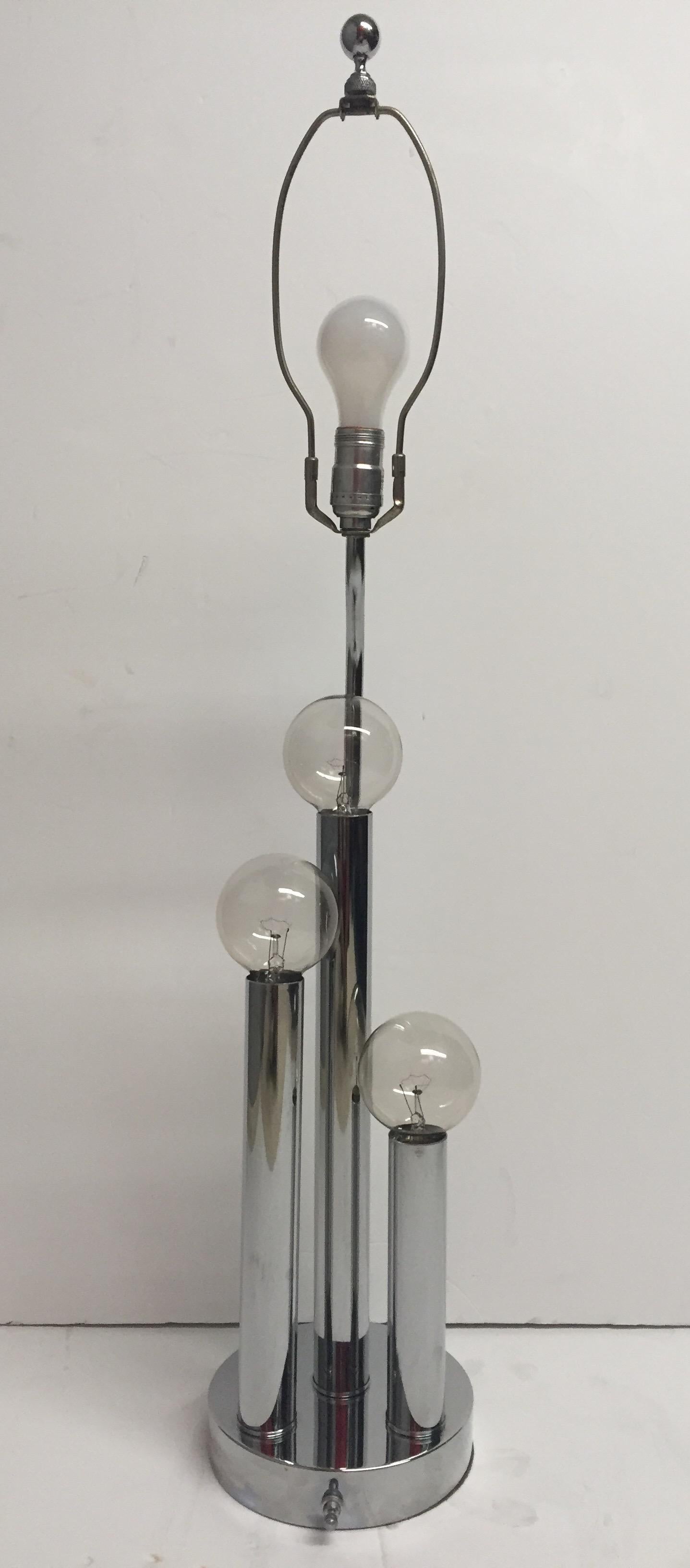 Retro chrome Mid-Century Modern table lamp having three columns in differing heights topped with cool round lightbulbs. Elongated black lacquer shade included.
Measures: Chrome base is 7.5 round 1.5 deep
25.5 inches high to socket.

40 watts per
