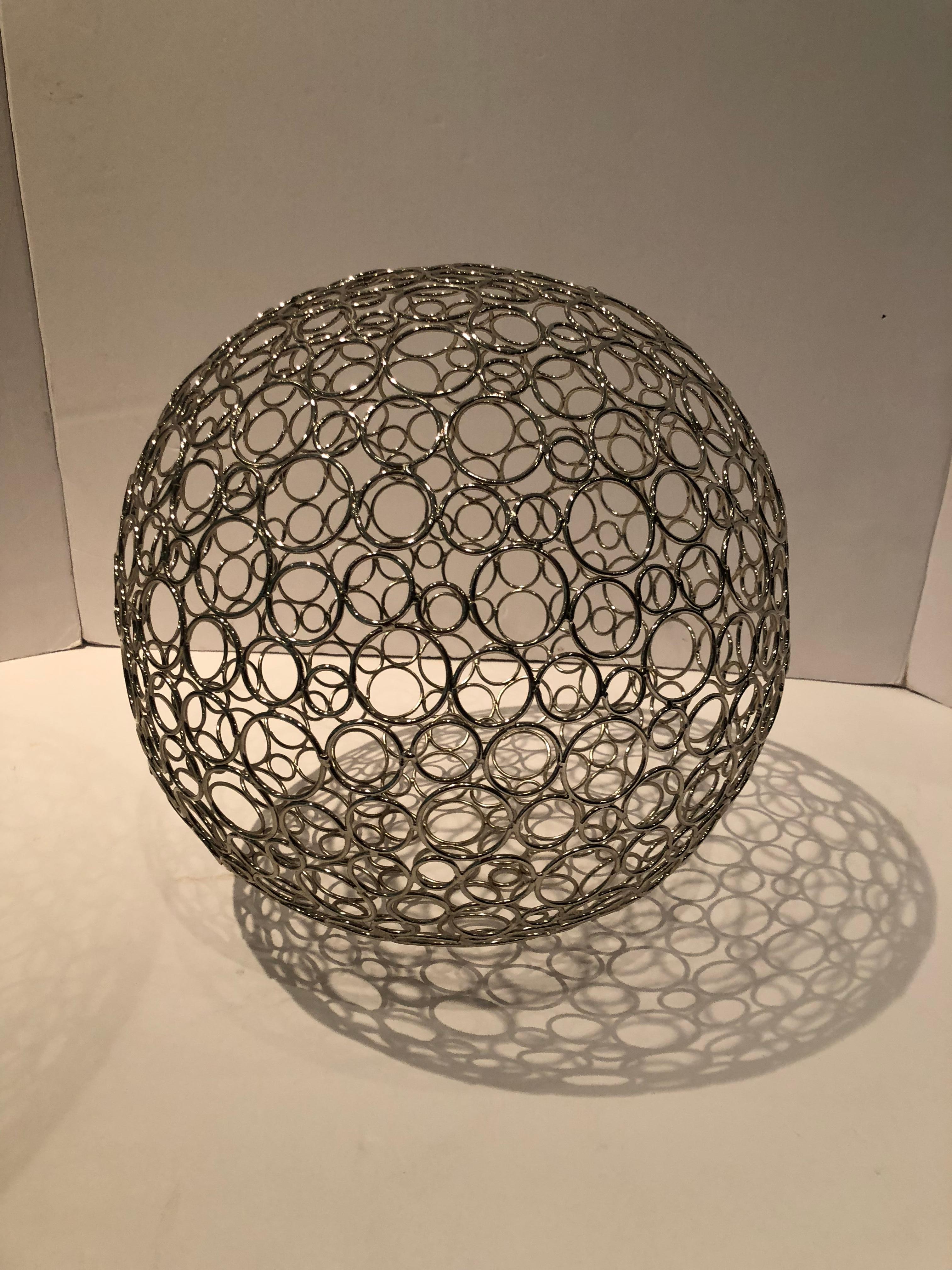 An eye-catching pair of wire spheres meticulously created by an artist by soldering each circle individually. Both spheres are made of solid brass with nickel plating. One is slightly more nickel in color than the other, but hardly noticeable. The