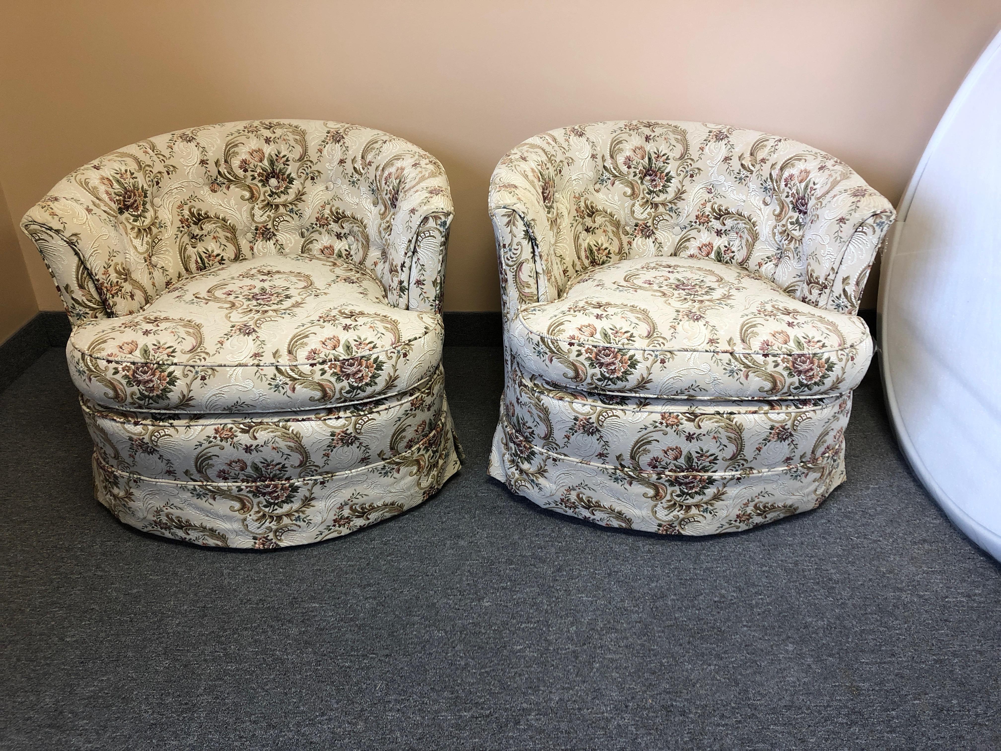 A comfy Mid-Century Modern pair of swivel club chairs having button tufted backs and original upholstery.