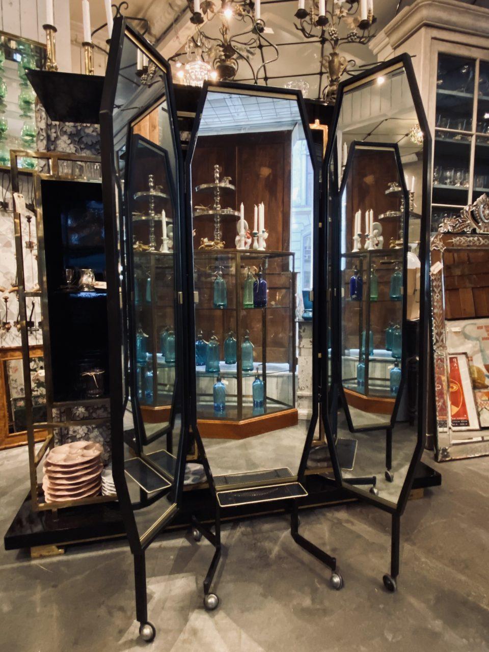Gorgeous retro Italian 3-panelled dressing mirror, circa 1950s-1960s. Each 3 octagon shaped mirror frames are black painted metal and with decorative brass moldings, as well as a shelf in perforated metal.

The mirrored glass is original, and the