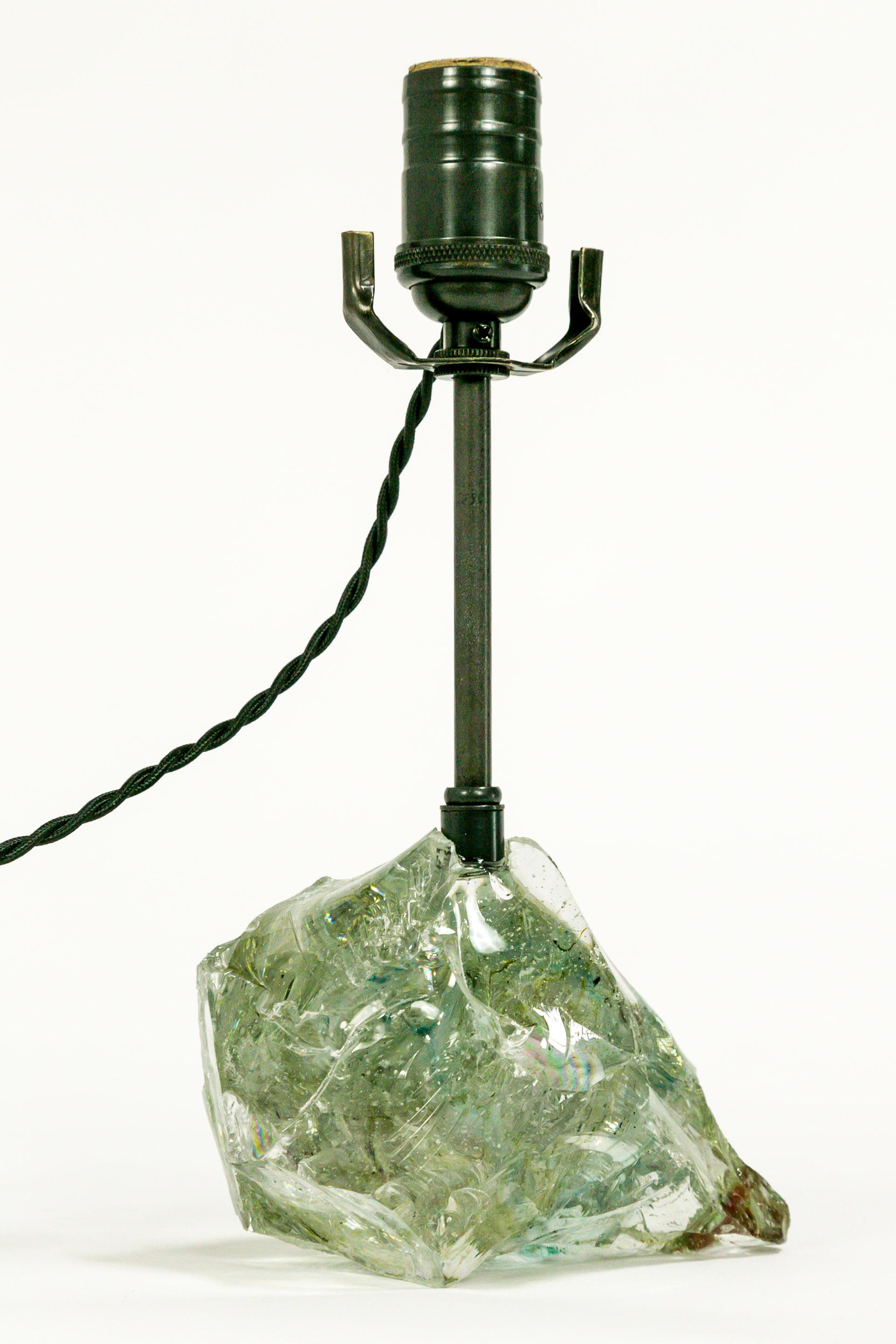 We fabricated this cool toned clear, and blue-green (with a red fleck), annealed cullet glass into a French wired table lamp. It's brass parts have an oil rubbed bronze finish, with a twisted, black, rayon covered cord with an inline switch.