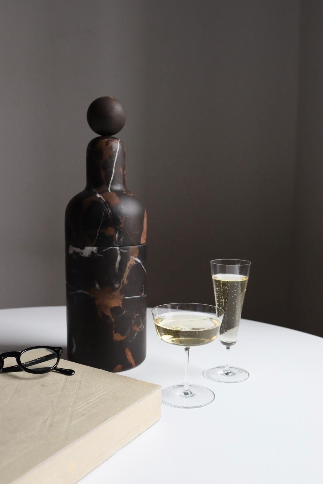 A bottle cooler that preserves the temperature of the bottle in the most natural way, avoiding the use of ice.
Made in Black and Gold marble, with a brass glass inside.
It is conceived to host all standard sizes of both wine and champagne