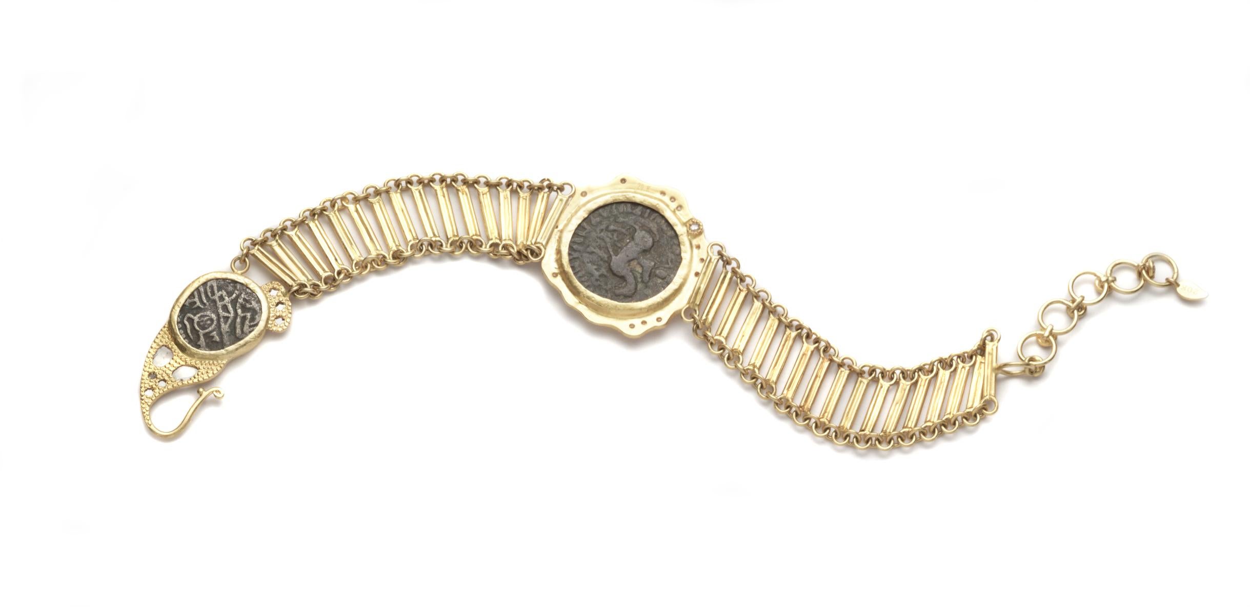 Bracelet Coomi en or jaune 20 carats, fabriqué à la main, avec deux pièces de monnaie anciennes indo-grecques au centre et au fermoir, une bande en forme d'échelle et des diamants brillants et plats de 0,67 ct.

Le bracelet mesure 8 pouces de long