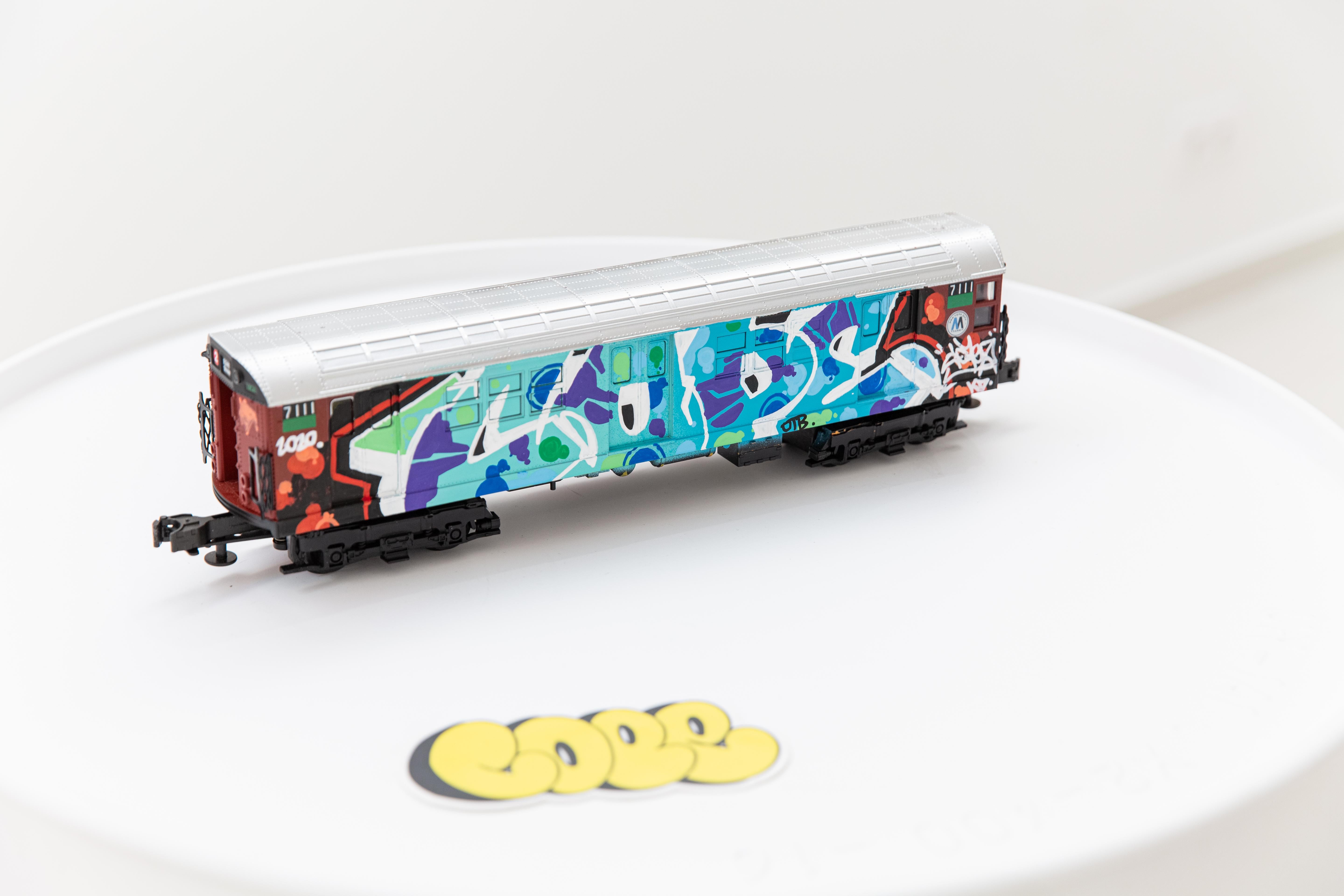 NYC Brown Train – A Hand-Painted Graffiti Masterpiece by COPE2
Artist: COPE2
Title: NYC Brown Train
Medium: Paint Marker on Model Train
Dimensions: 36 x 9 x 6.5 cm / 14.2 x 3.5 x 2.6 in
Edition: Unique, hand-painted
Condition: Excellent
The NYC