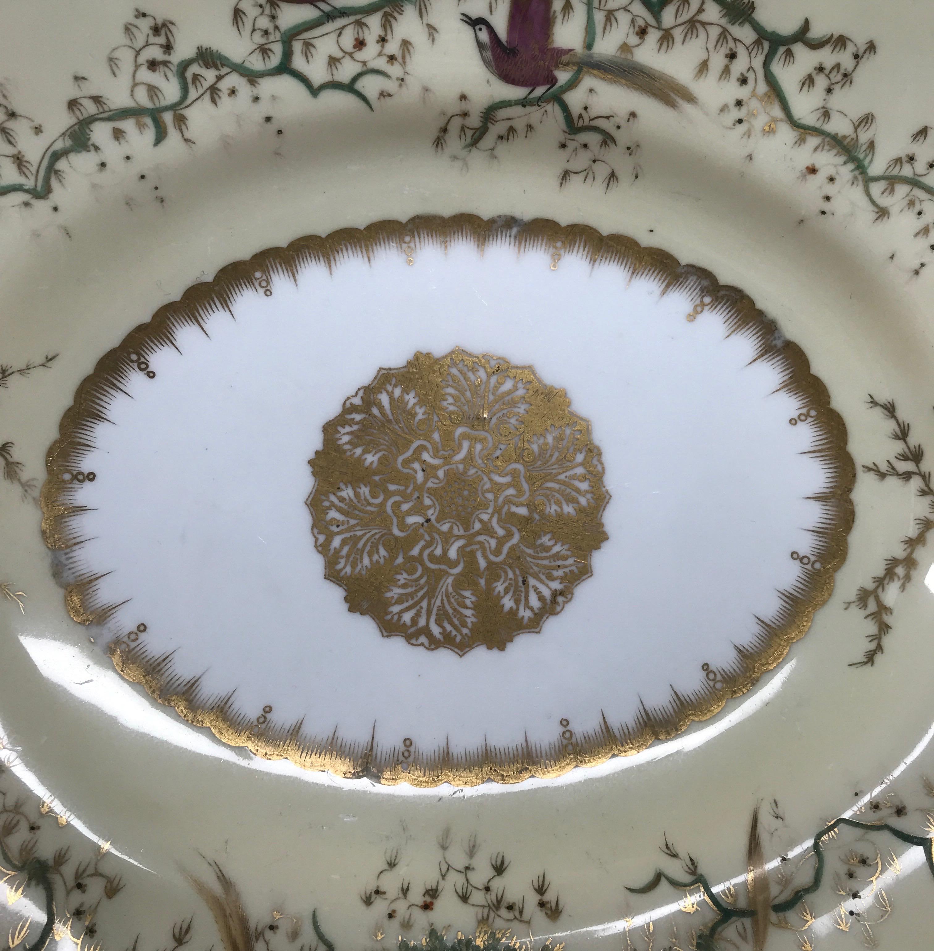 Copeland & Garrett serving dish, the ornate shape with a border of pale yellow hand painted with birds in branches, one side with a nest of young, all with gold highlights, the center with a large gilt roundel.

Printed green 'Copeland & Garrett'