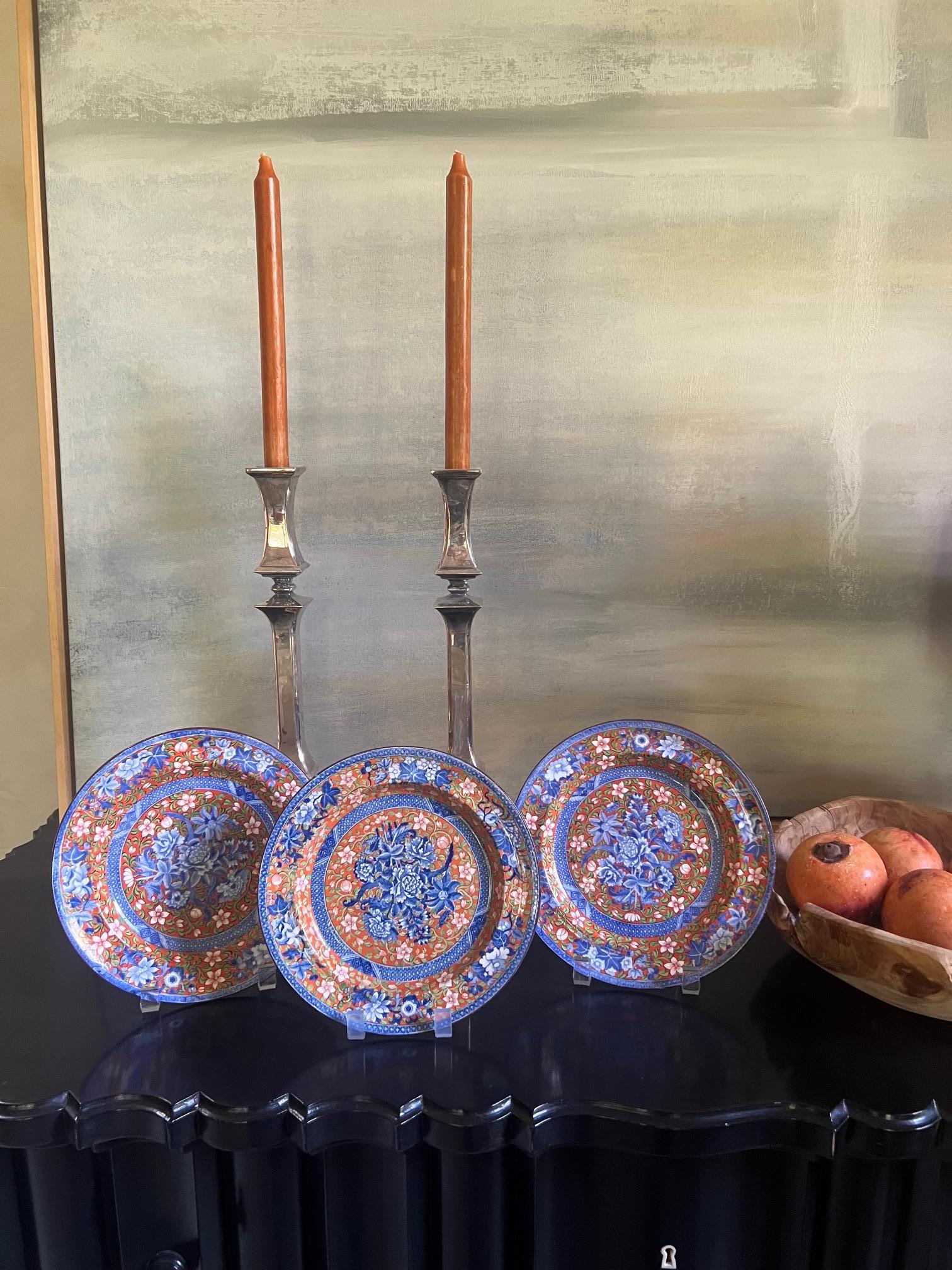 Ensemble de trois assiettes en porcelaine polychrome, fabriquées par Copeland Spode en Angleterre au début ou au milieu des années 1800. Des fleurs bleues vibrantes sur un fond terre d'ombre sont peintes à la main sur le glaçage de ce motif numéro
