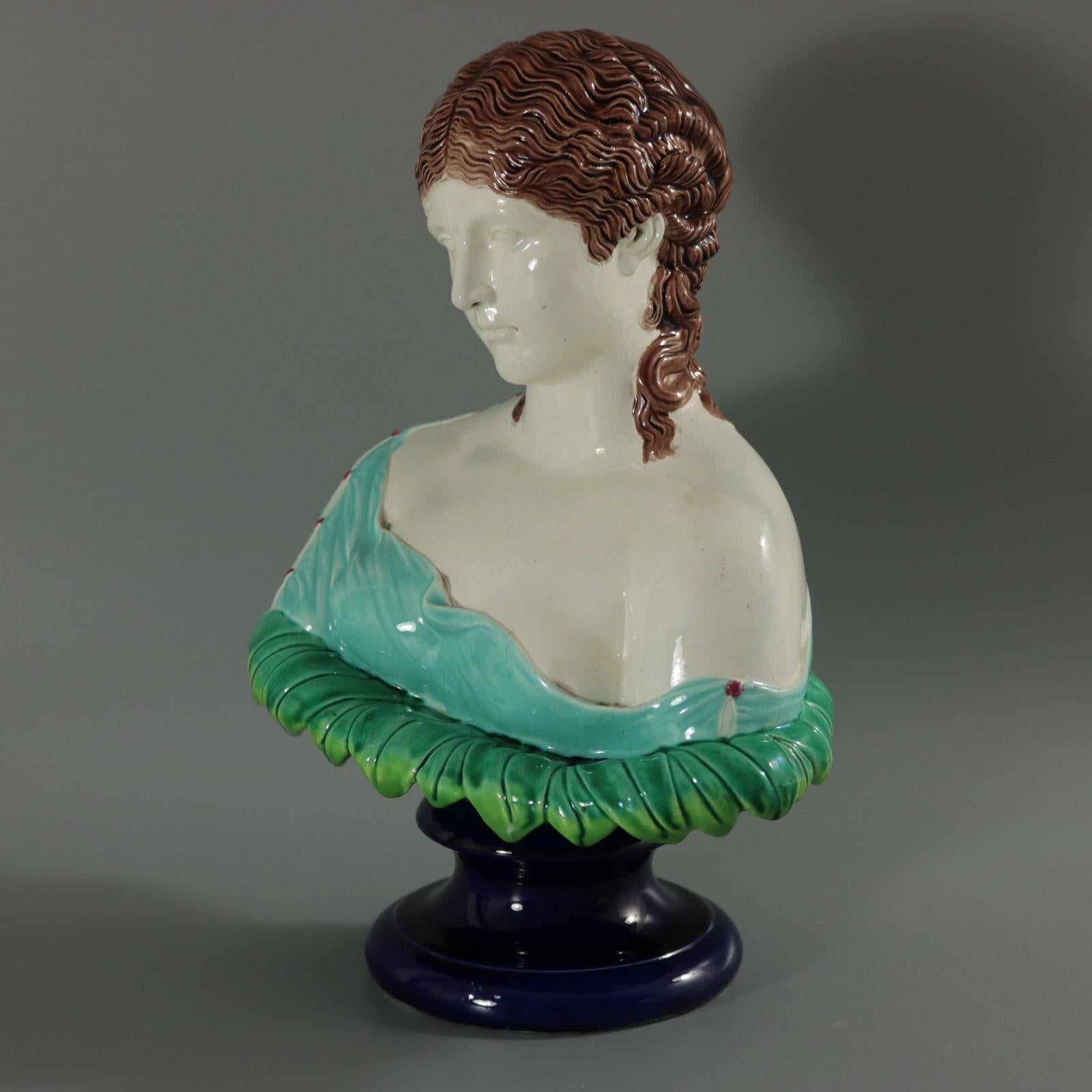 Copeland Majolica bust which features head and shoulders of a woman on a bed of leaves. Sits on a socle base. Colouration: white, turquoise, green, are predominant. This piece represents Clytie the water nymph, daughter of the Titans Oceanus and