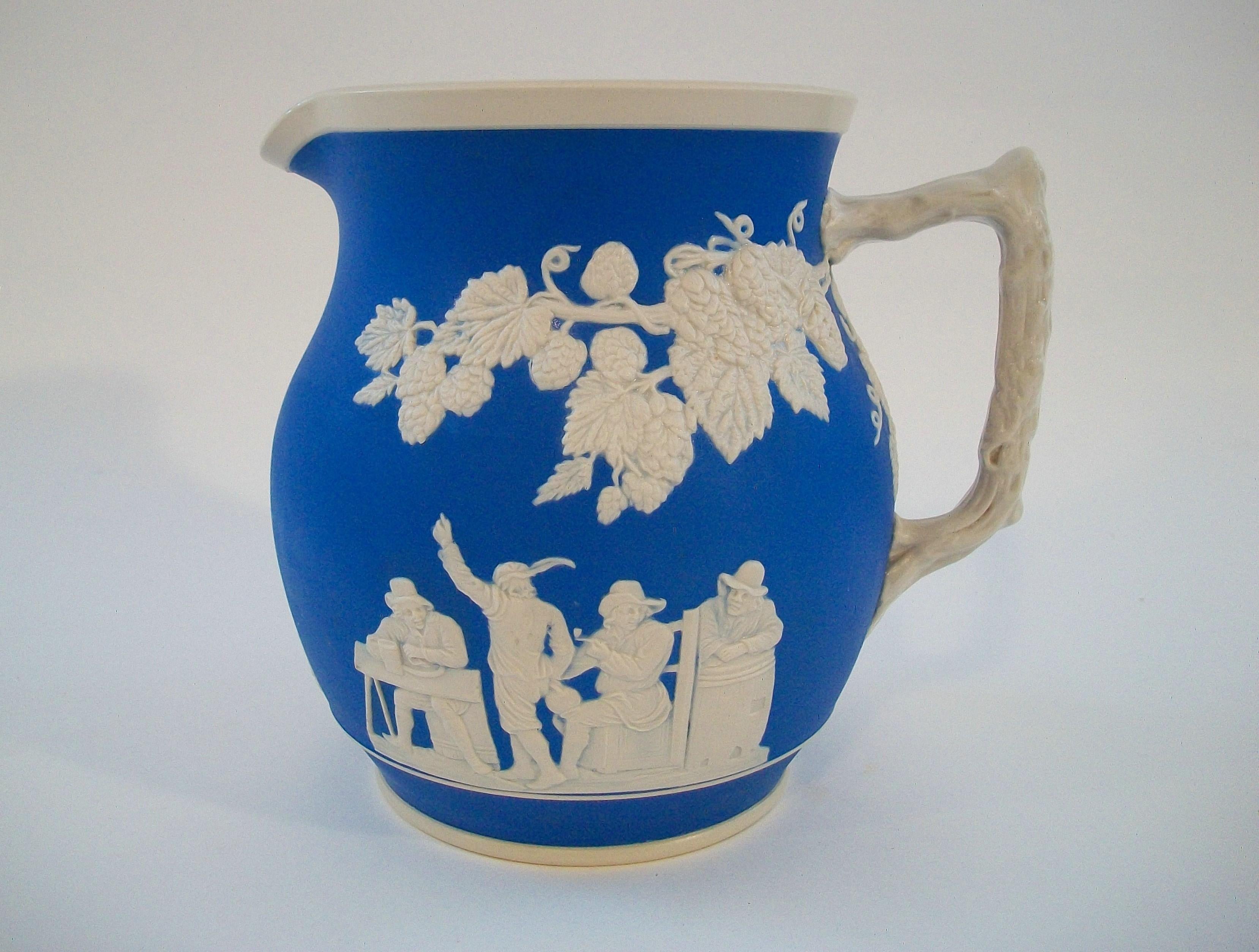 COPELAND SPODE - Rare early antique blue and cream jasperware pitcher - large size - featuring a twig style handle with applied raspberry vines with fruit and leaves to the neck - three appliques of merry makers to the body - glazed interior -