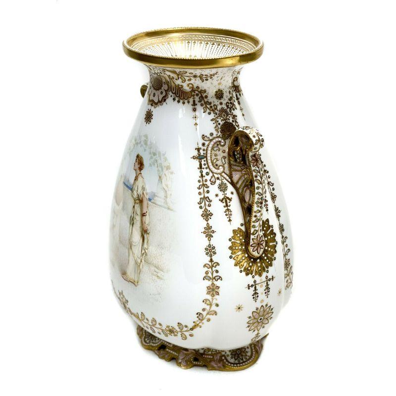 Copeland's England enamel jeweled twin handled urn, Artist Signed, 19th century.

The central area depicts a hand painted beauty in long white robed garbs looking out from an oceanic balcony. Artist signed Alcock to the lower edge. Gilt handles