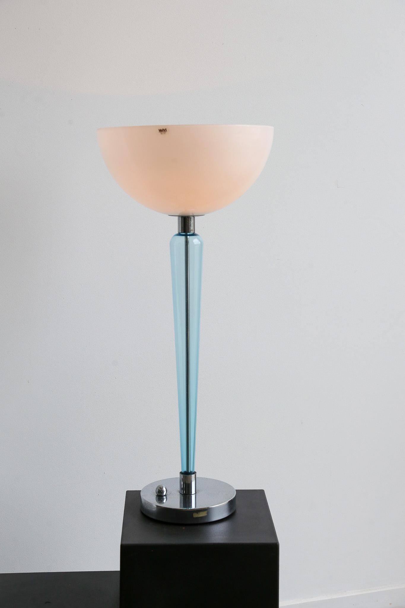 Designed by Jeannot Cerutti and produced by Ve-Art, Coppa is a magnificent table lamp with a vintage and elegant design, perfect for furniture lovers with a retro touch. The lamp is composed of two parts in blown Murano glass, light blue and white