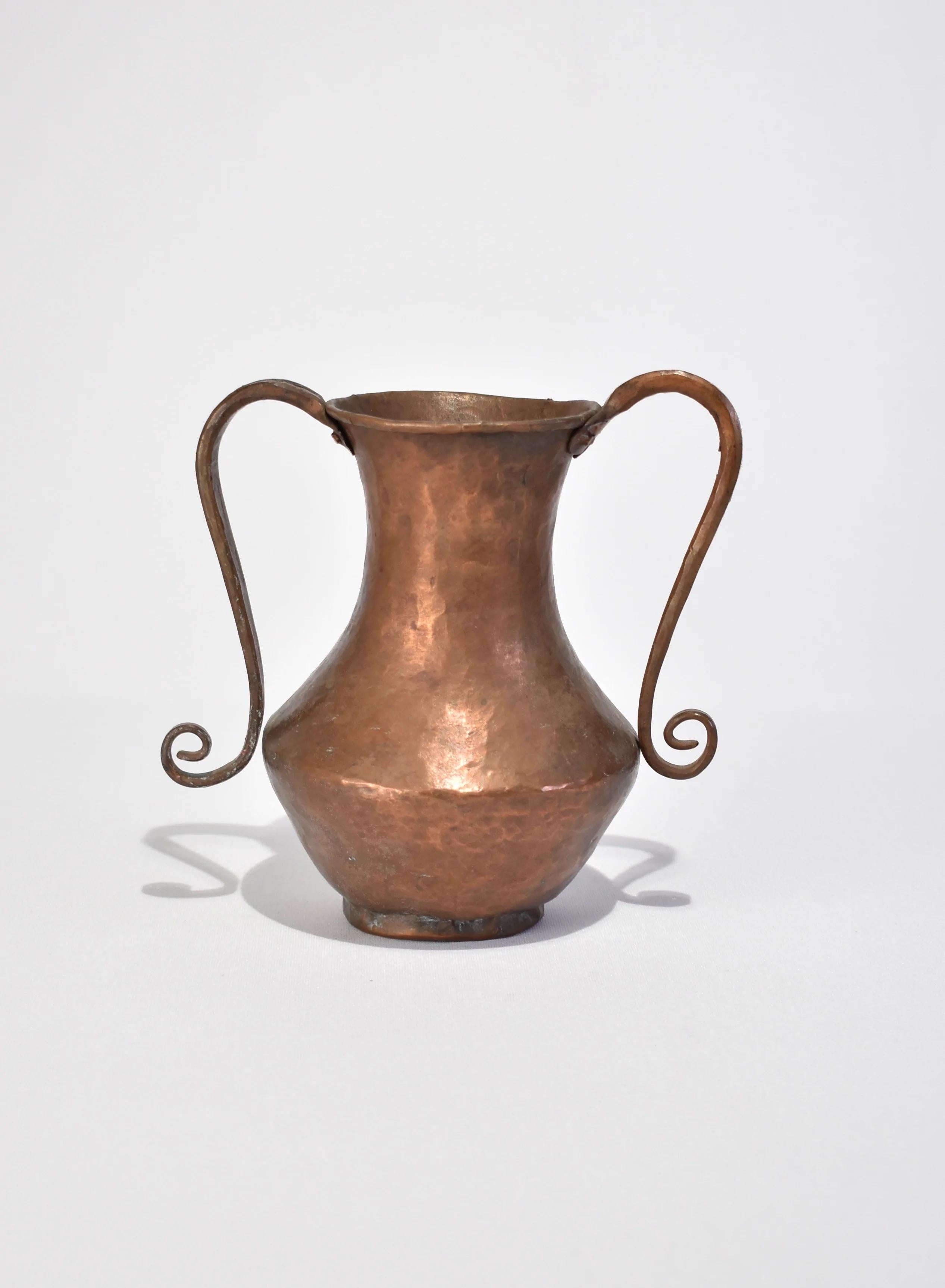 Vintage hammered copper amphora vase with spiral handles.
 