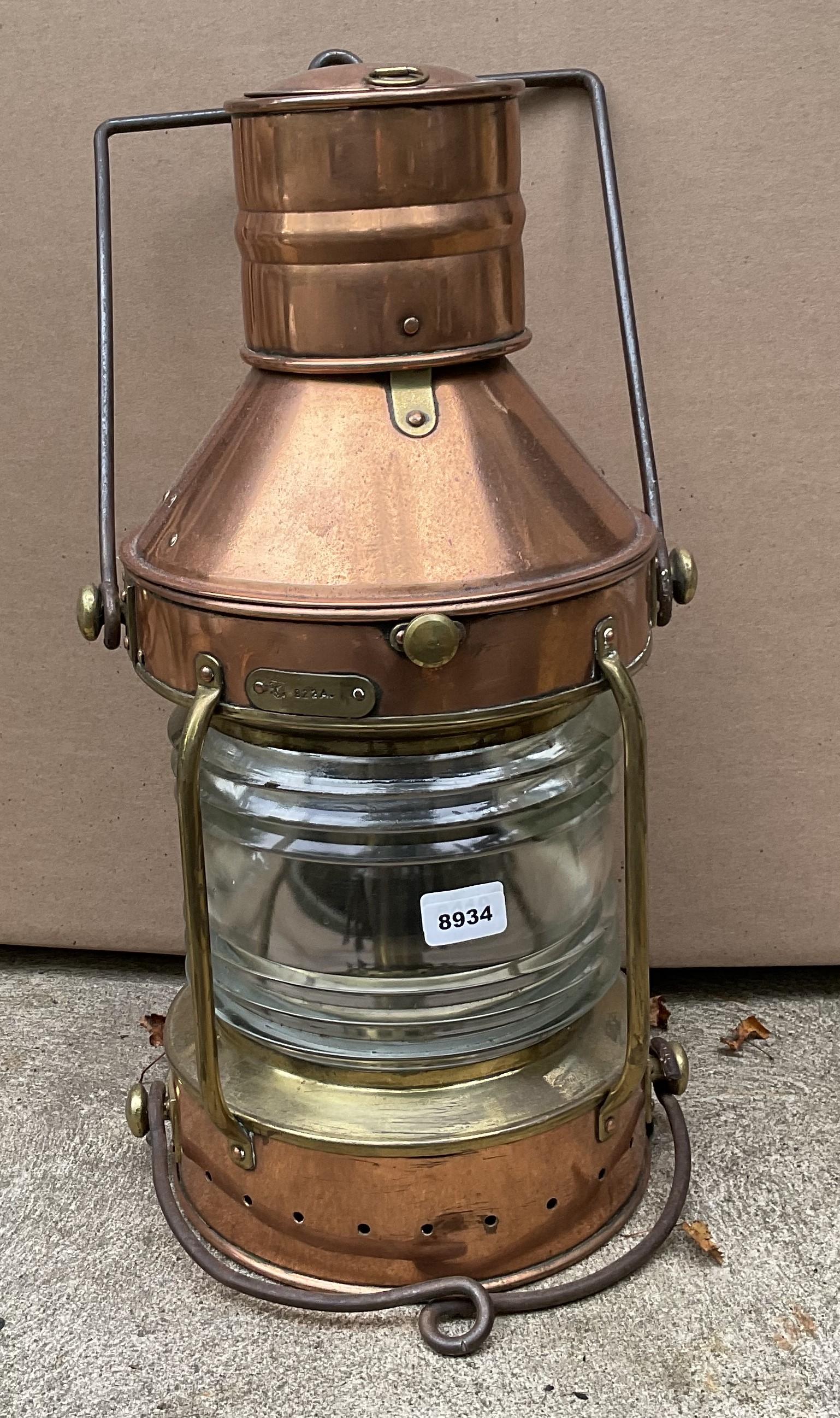 Polished copper ships lantern with fresnel lens, iron hoist and bale handles. Hinged top with brass hasp and protective bars. 21