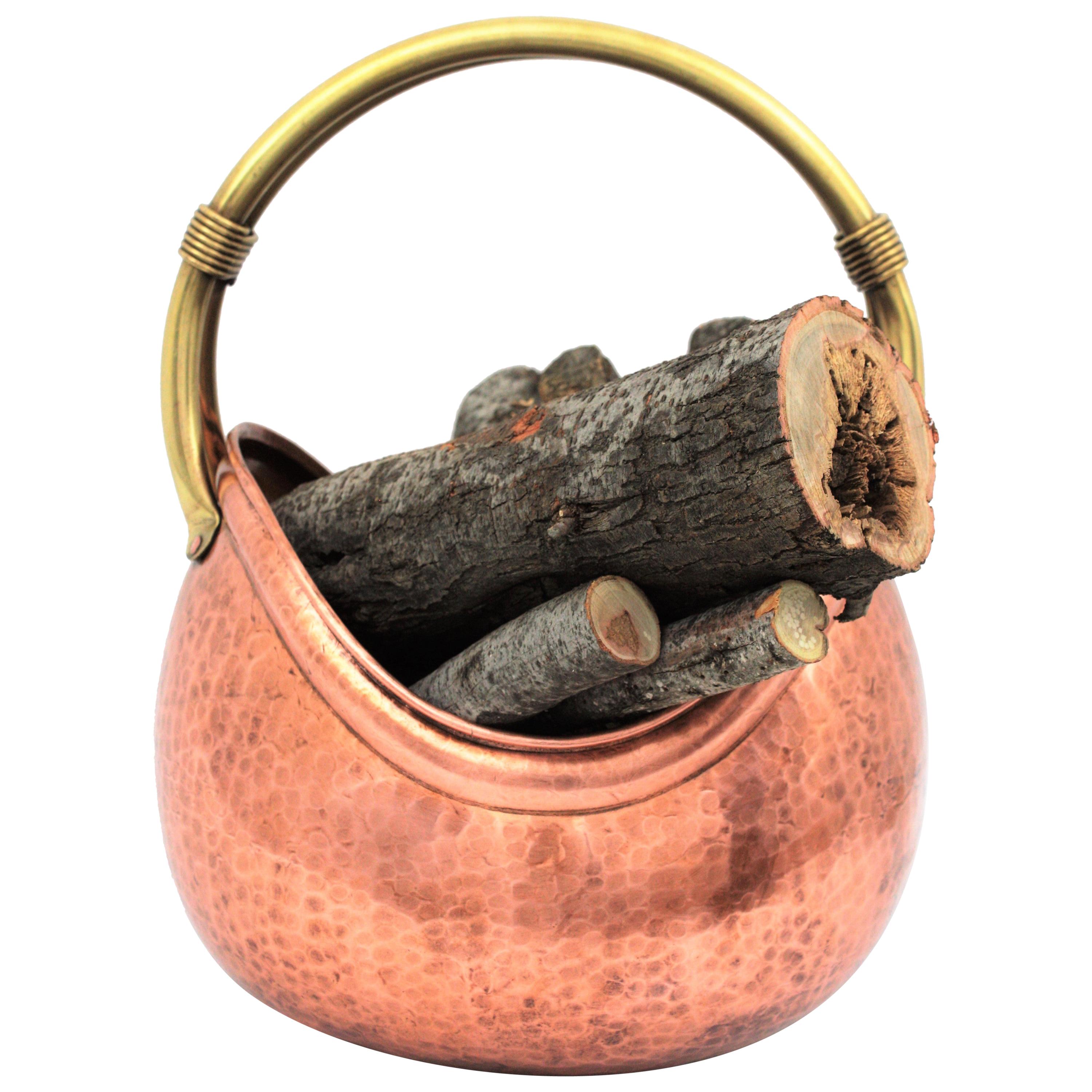 Exquisite copper and brass decorative basket or log holder or jardinière or magazine stand, France, 1950s.
This luxury handcrafted Mid-Century Modern basket is made with hand-hammered polished copper and it has a brass handle to hold it with rope