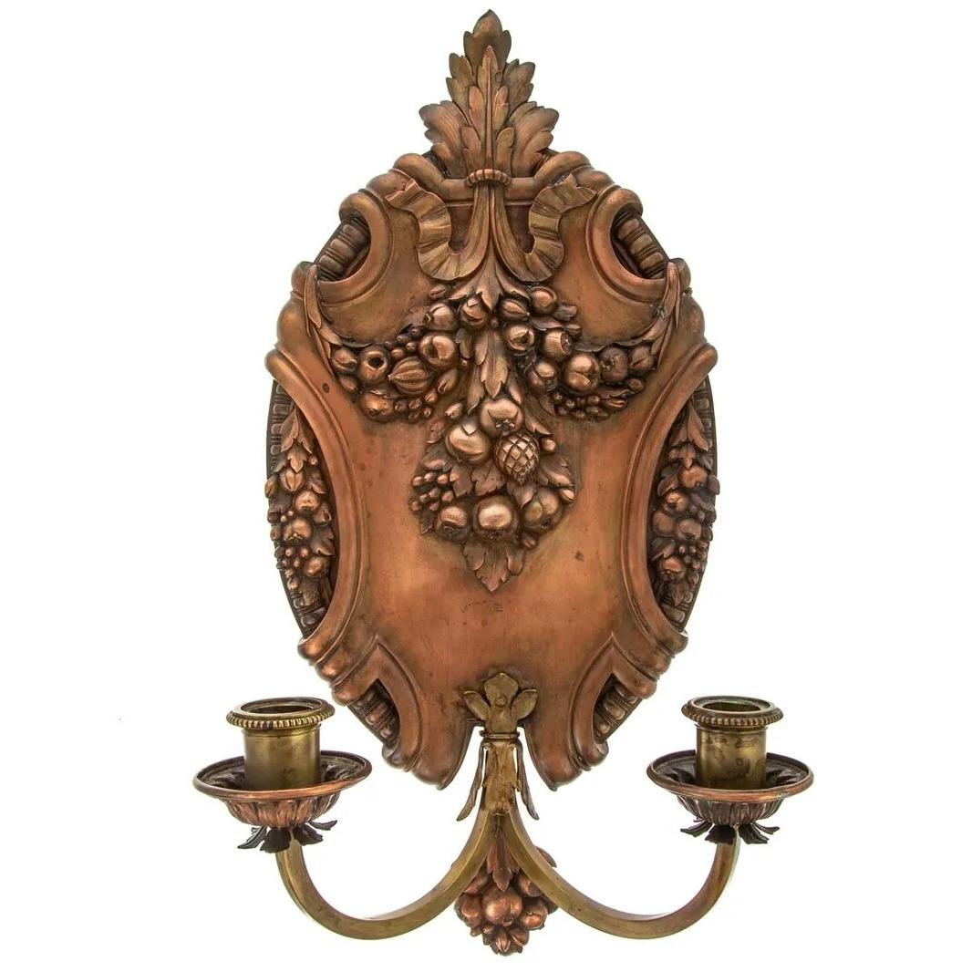 A very fine pair of heavy gauge cast copper cartouche form sconces with brass candelabra arms holding crisply cast copper rosette form drip pans and brass nozzles. Exceptional quality workmanship throughout- crisply formed garland motifs and