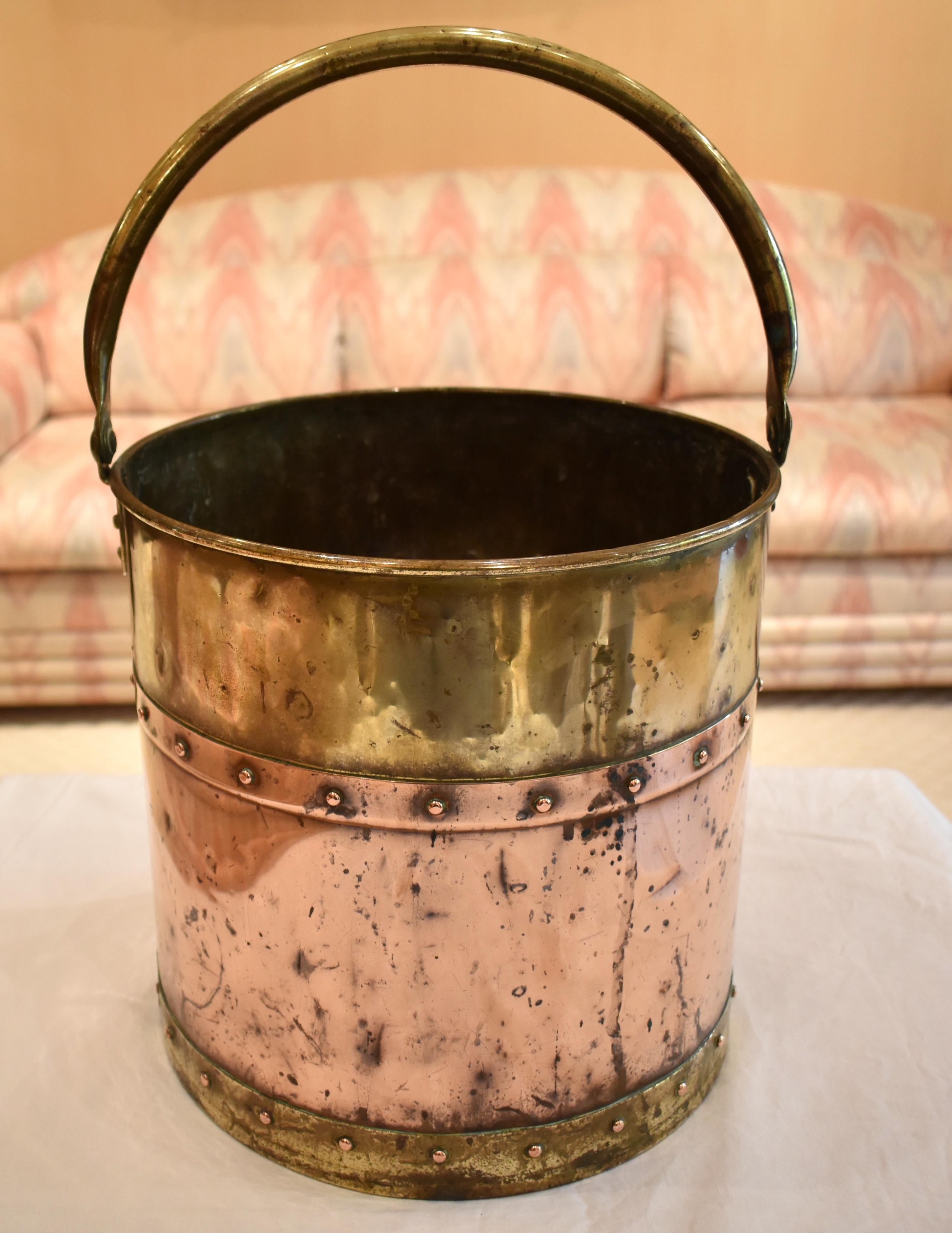19th century antique copper and brass coal bucket with a brass swing handle attached to a lovely round copper and brass bucket. Gathered wonderful character over the years and in lovely condition, circa 1800.