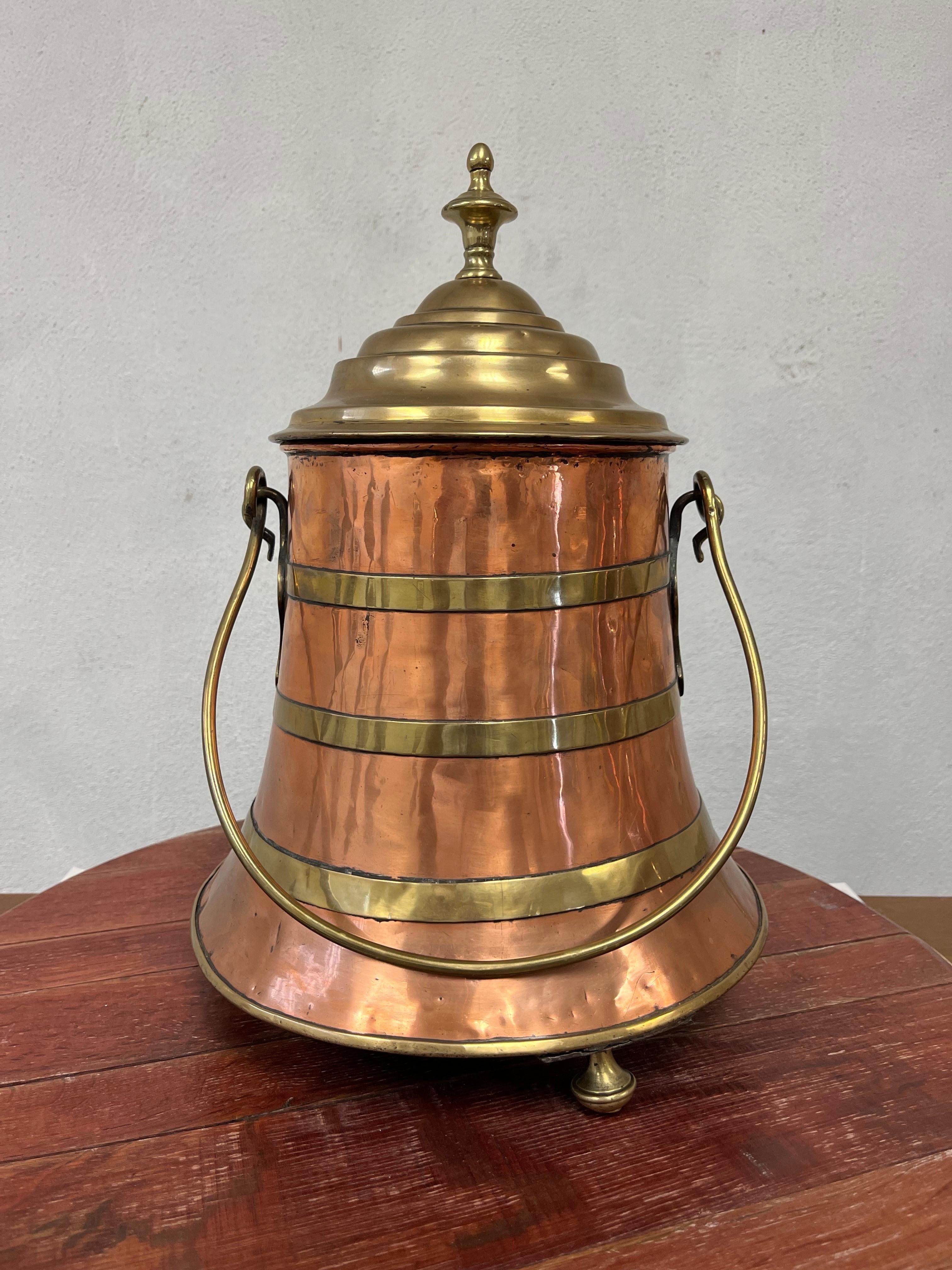 Pot à charbon en cuivre et laiton fabriqué à la main. Belle patine des métaux contrastés. Design/One joliment bandé, avec une poignée joliment évasée et un superbe ornement de fleuron. Un véritable survivant avec des siècles d'histoire. 

