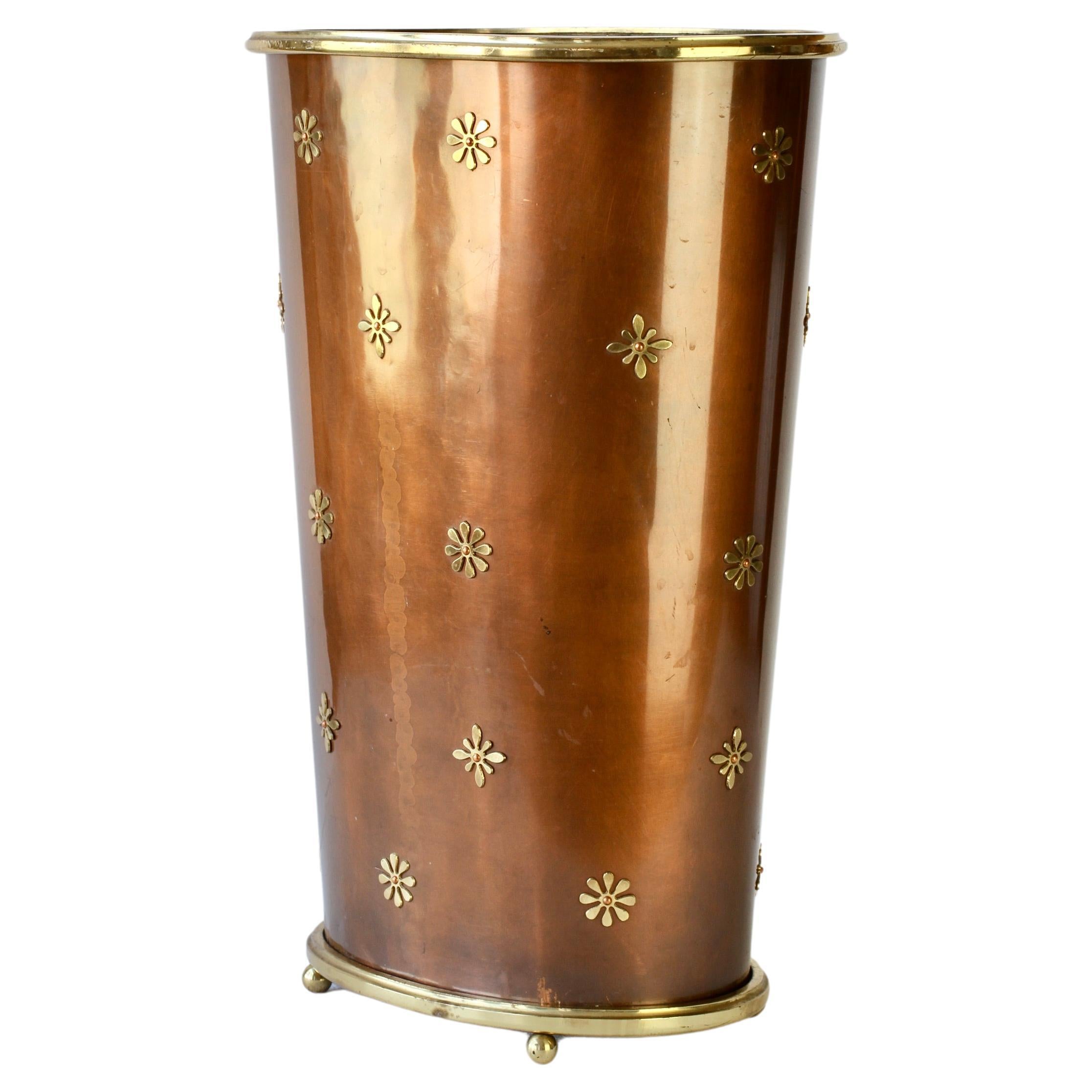 Delightful handcrafted German Mid-Century modern umbrella stand or holder by the Vereinigte Werkstätten (Atelier) München, circa 1955. Handmade in patinated copper with cast brass trim and base, finished with delicate brass flower petal details.