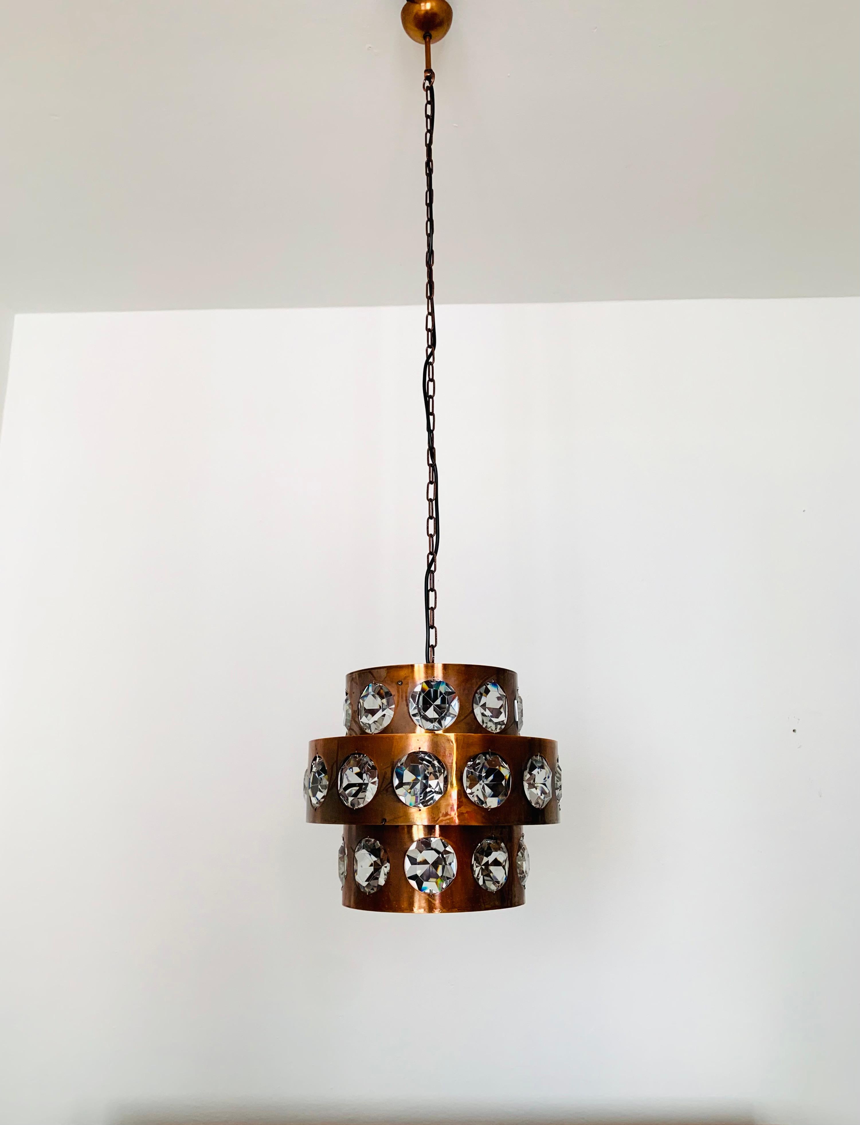 Eccezionale e grande lampada in rame degli anni '60.
I 31 cristalli di grandi dimensioni sono impressionanti e conferiscono alla cornice in rame massiccio un tocco nobile e delicato.
La lampada è di alta qualità.
Nella stanza si crea un grande gioco