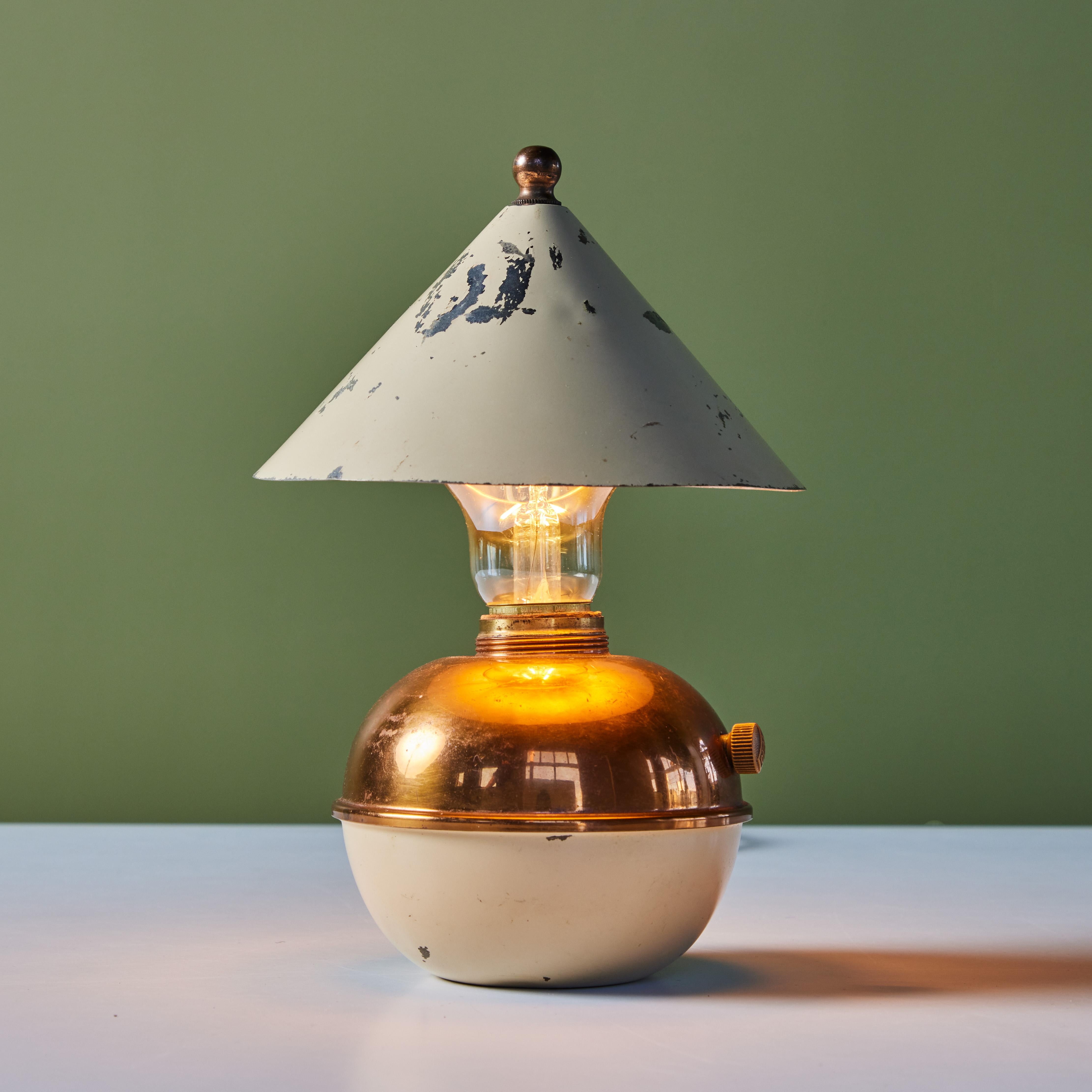 Petite copper and enamel table lamp by Ruth Gerth for Chase, c.1930s, USA. The Art Deco lamp features a cone shaped shade in white enamel and bulb body, half copper and half enamel. The minimalist design is playful and a fun piece to add to a shelf
