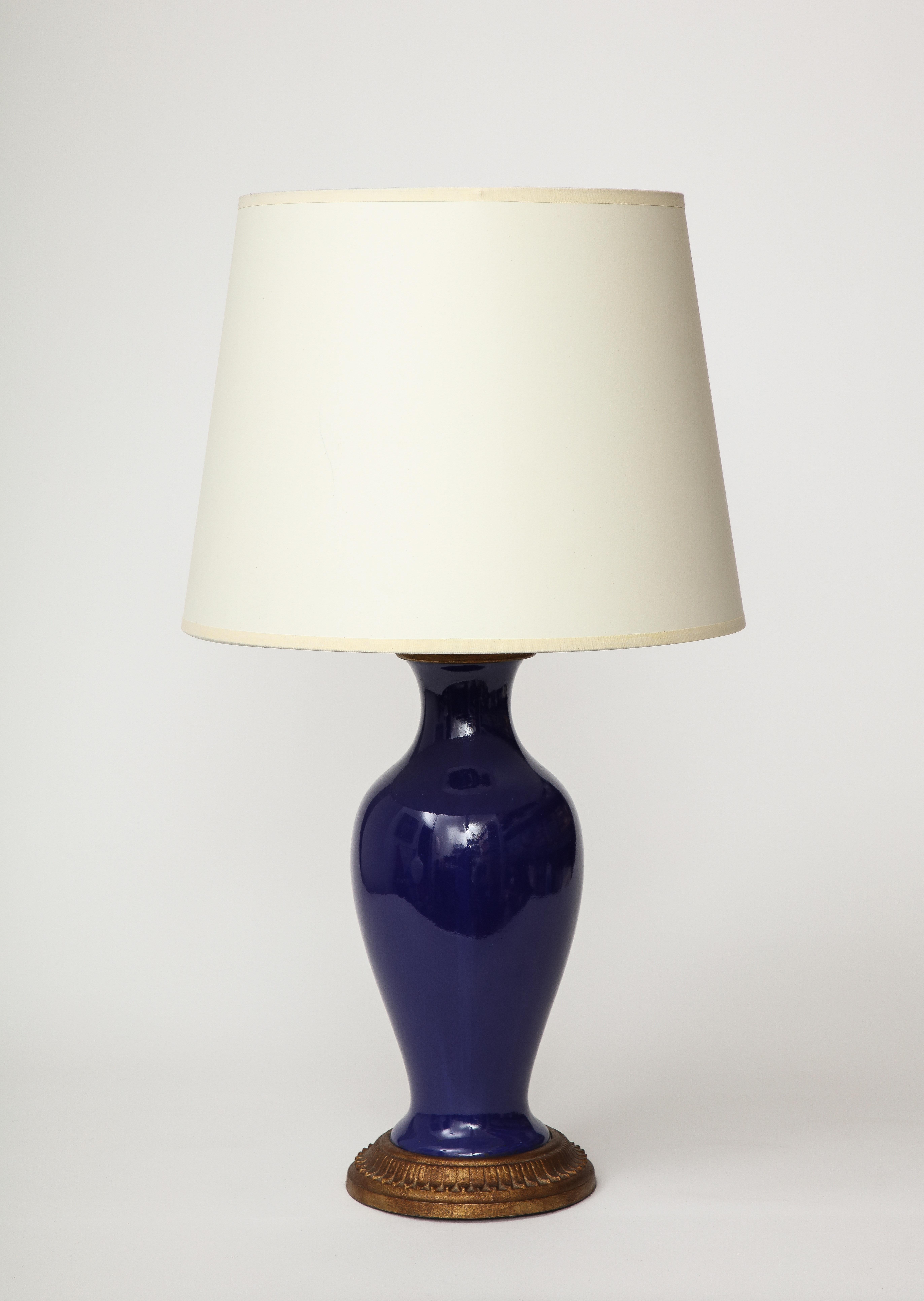 Small, classic table lamp made of copper coated with deep blue lapis enamel.

This table lamp was recently rewired with a black twisted silk cord, bronze hardware, a dimmer at the neck, and an adjustable shade harp.

Overall Height: