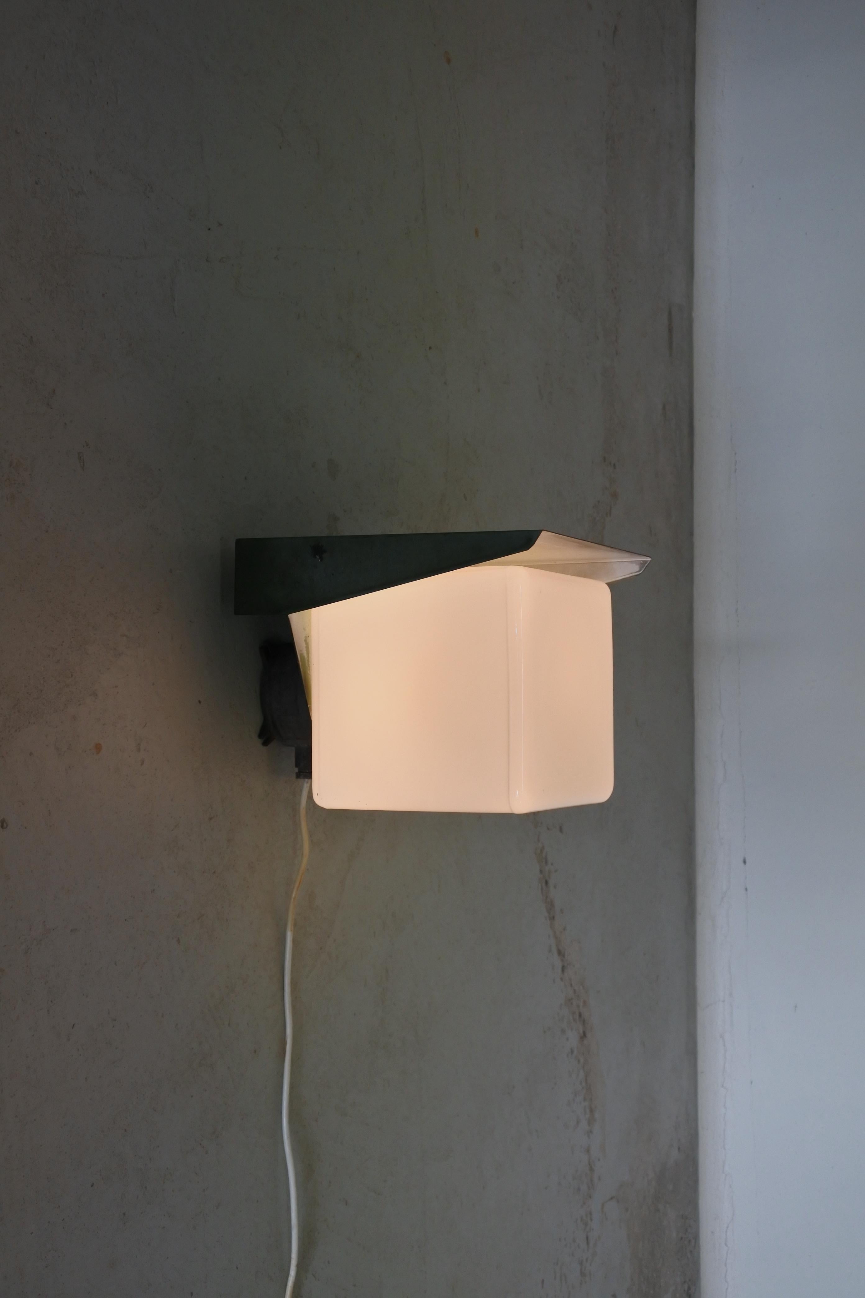 Wall lamp made by Itsu Oy, model AT21
Finland 1950s.
Copper reflector and opaline glass mounted on an aluminium junction box.
Marked accordingly.

Outstanding patina. Scarce model. Ideal as a porch light.

Literature: Itsu catalogues of the