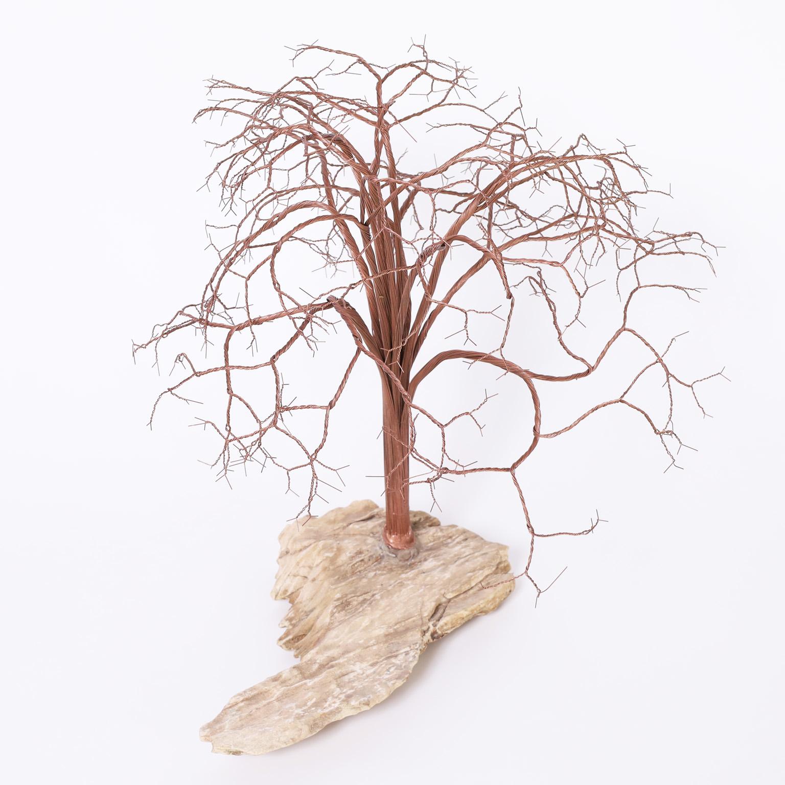 Lofty mid century tree sculpture crafted in copper twisted into form and mounted on an organic stone base.