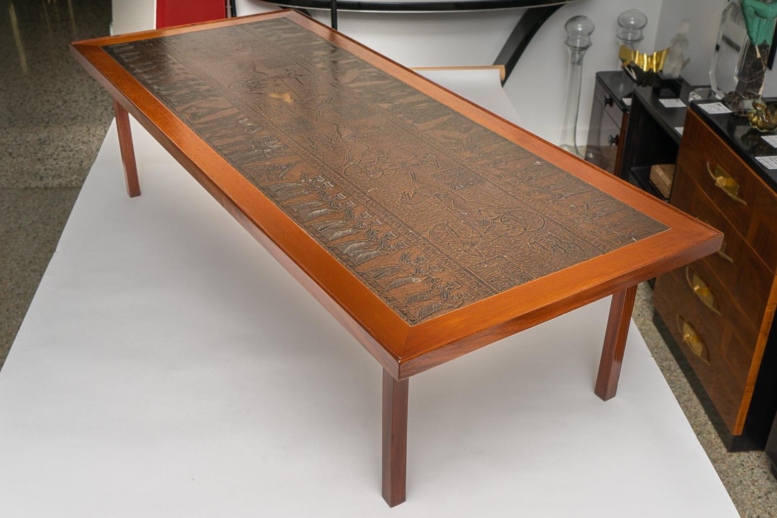 This stylish and chic midcentury Danish cocktail table will make a definite statement with its copper top which is embossed with stylized Egyptian motifs and characters. 

Note: The piece has been professionally restored as of August, 2019.