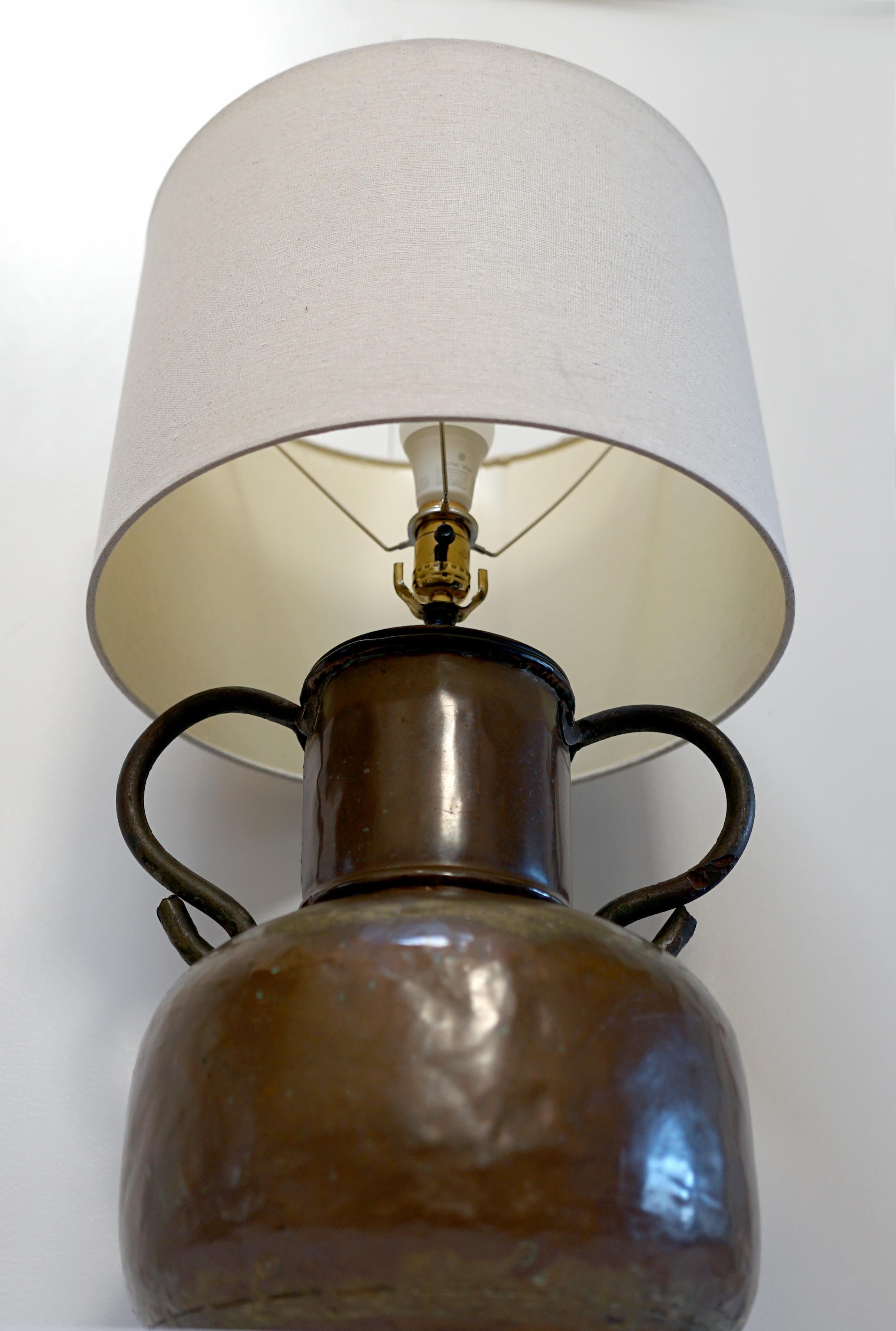 Cette lampe artisanale en cuivre a été produite en Angleterre ou en Amérique au début du 20e siècle, selon notre expert. Cette lampe est magnifique avec sa forme de tonneau et sa surface martelée. Il reflète le style Stickley, je crois, avec ses