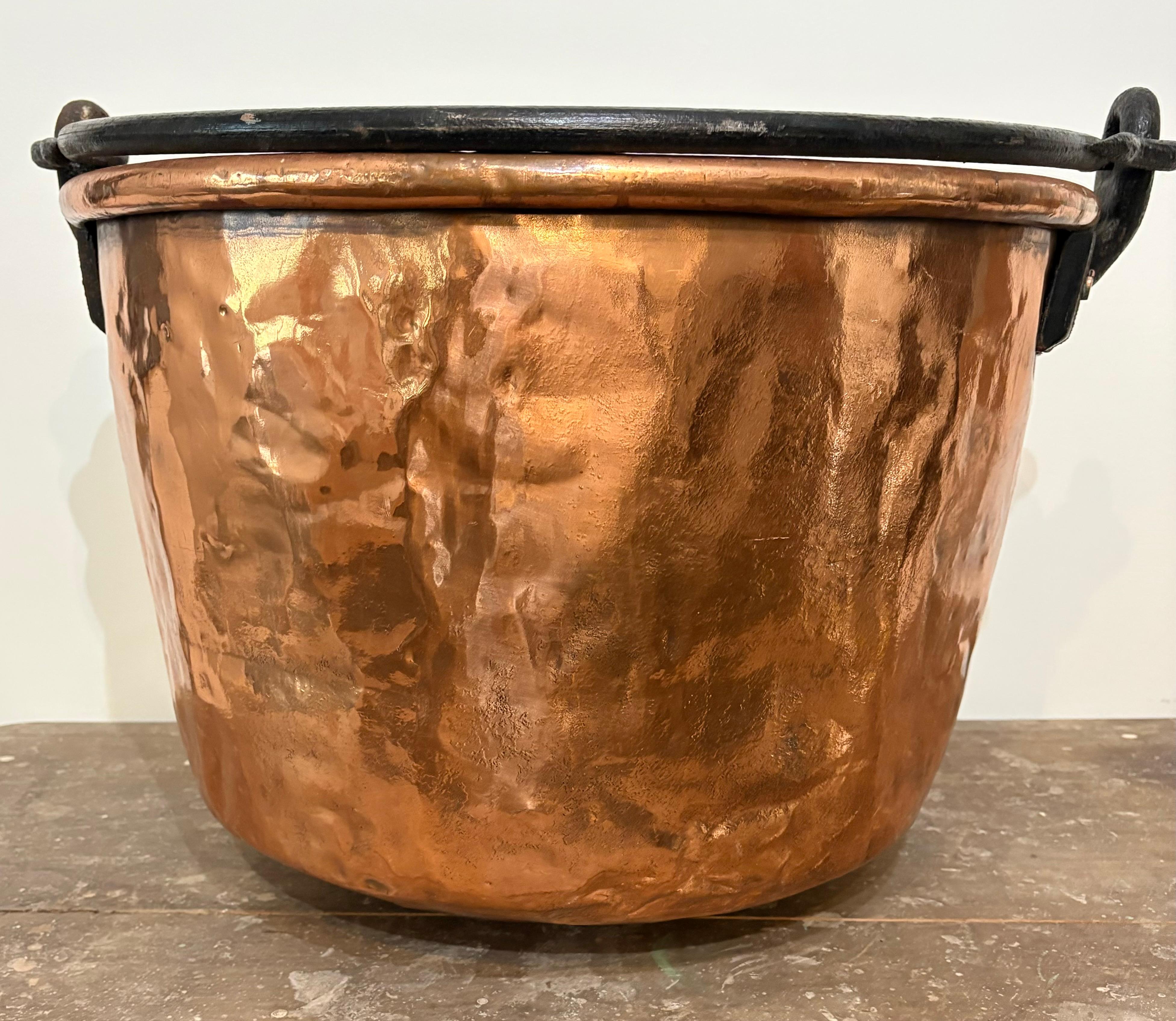 Grande calderone di rame del XIX secolo con bordo arrotolato e manico in ferro forgiato. Bellissima lucentezza del rame che presenta piccole imperfezioni dovute all'usura e alla patina, coerenti con la sua età.  Questo pezzo sarebbe splendido per la